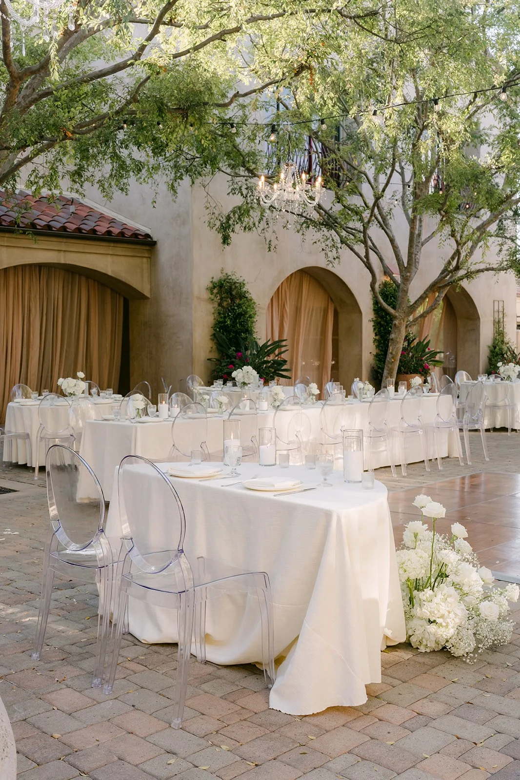 Round reception tables with white linens and floral arrangements