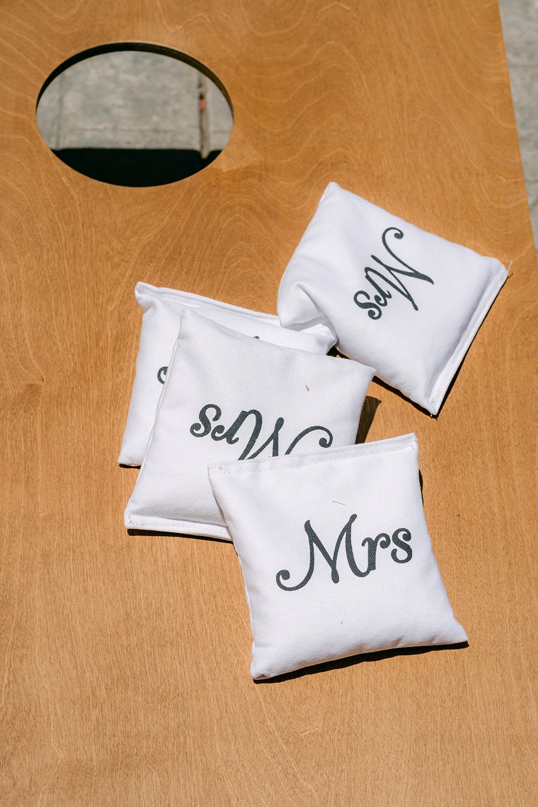 Mr and Mrs pillows resting on a wooden board, photographed by One and Only Production