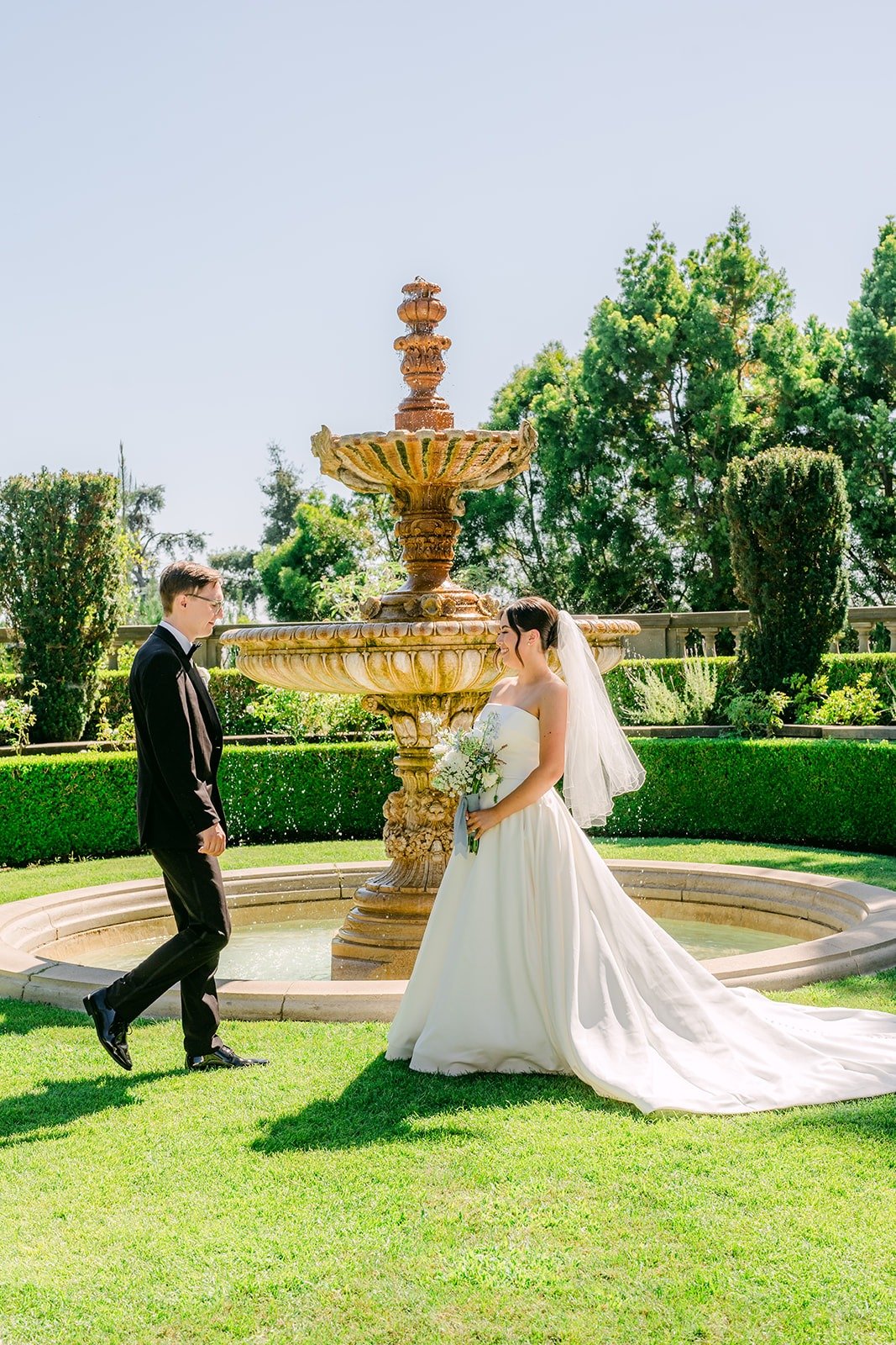 Brianna and Nik on the lawn with the tiered fountain behind them