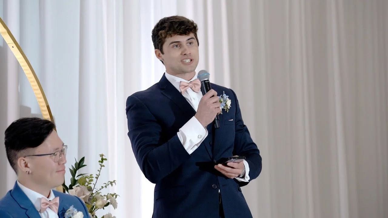 Video still of a toast at the Venue by Three Petals reception, filmed by One and Only Production