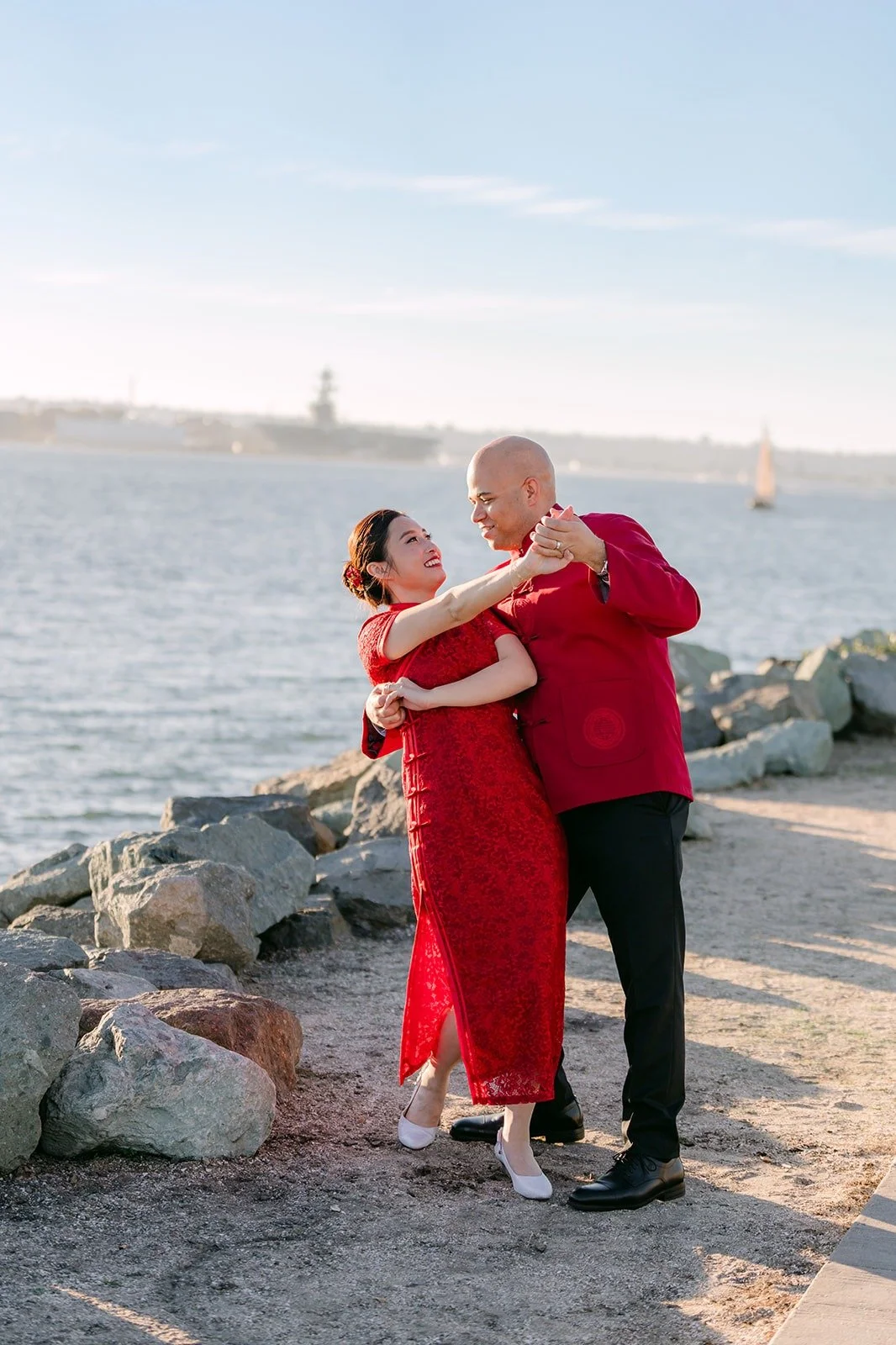 Elisa and Brandon on the rocky shoreline by the bay