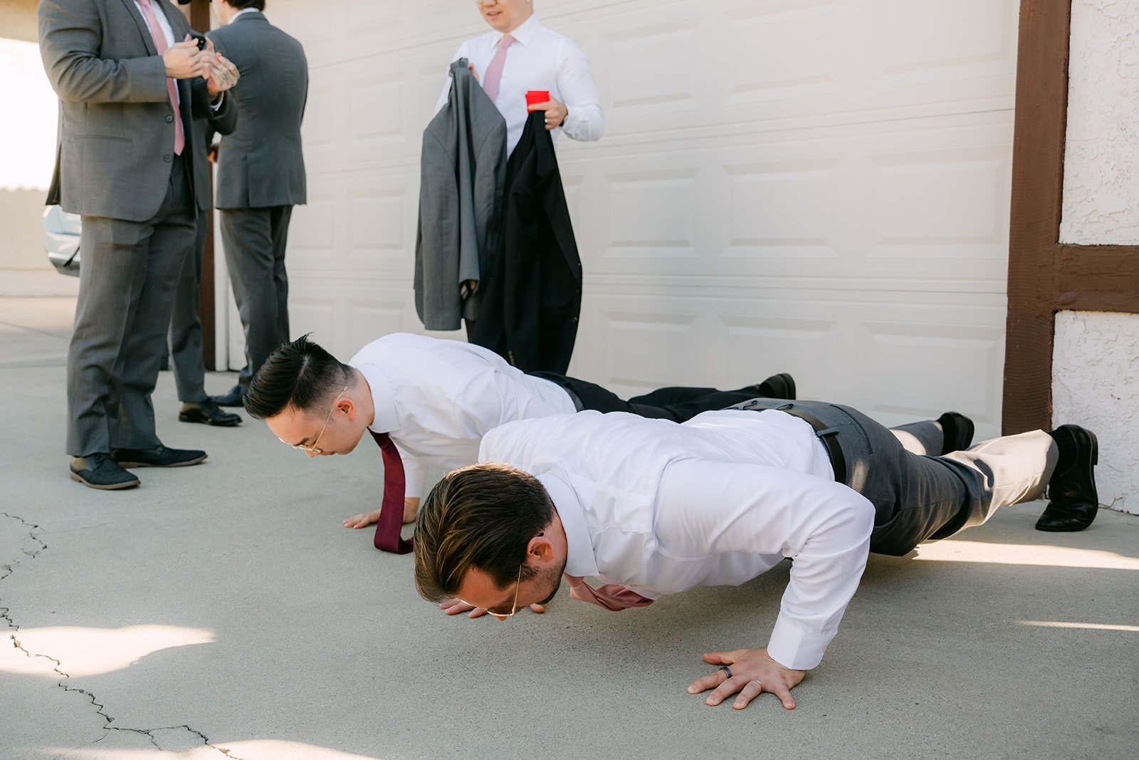 Groomsmen doing push ups together during the door game.