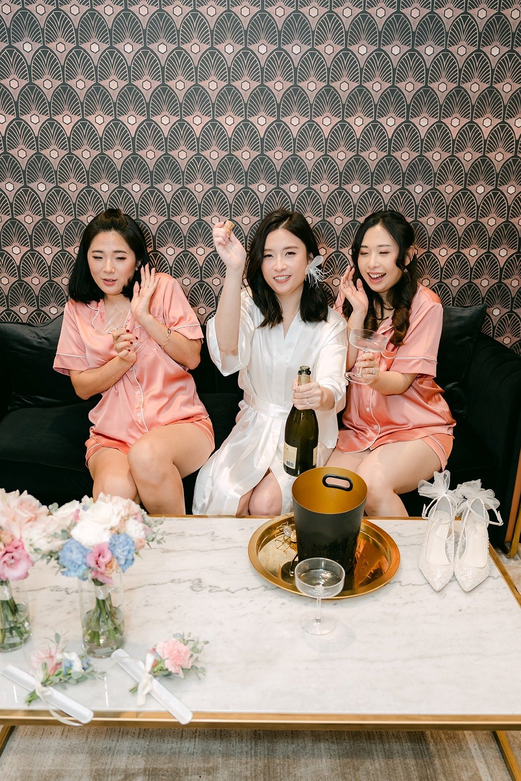 Elisa and her bridesmaids wave from the sofa while getting ready