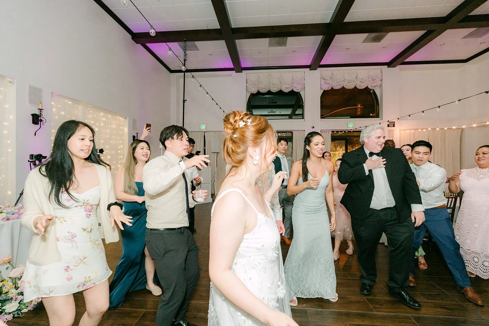 Guests filling the parlor dance floor under the beams