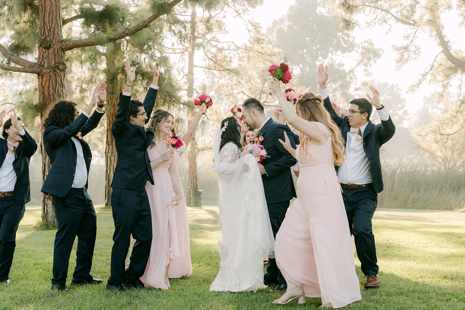 Wedding party cheering with bouquets raised