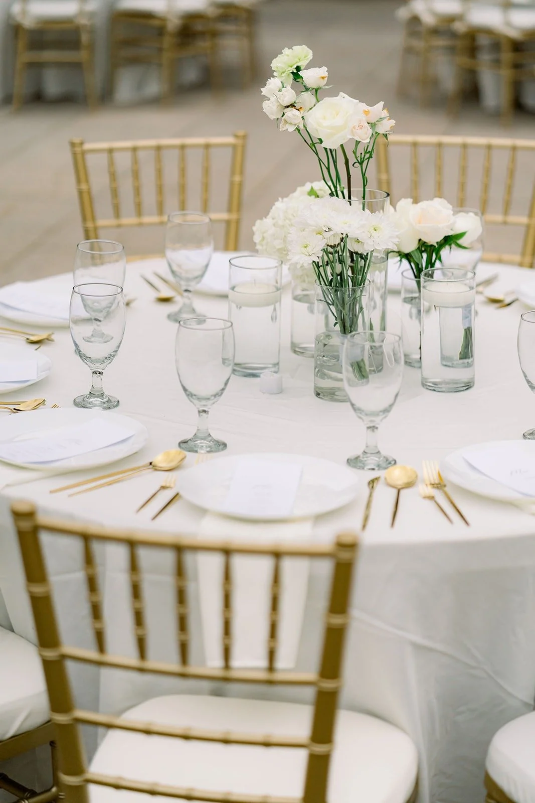 A table setting with white orchids and gold chairs