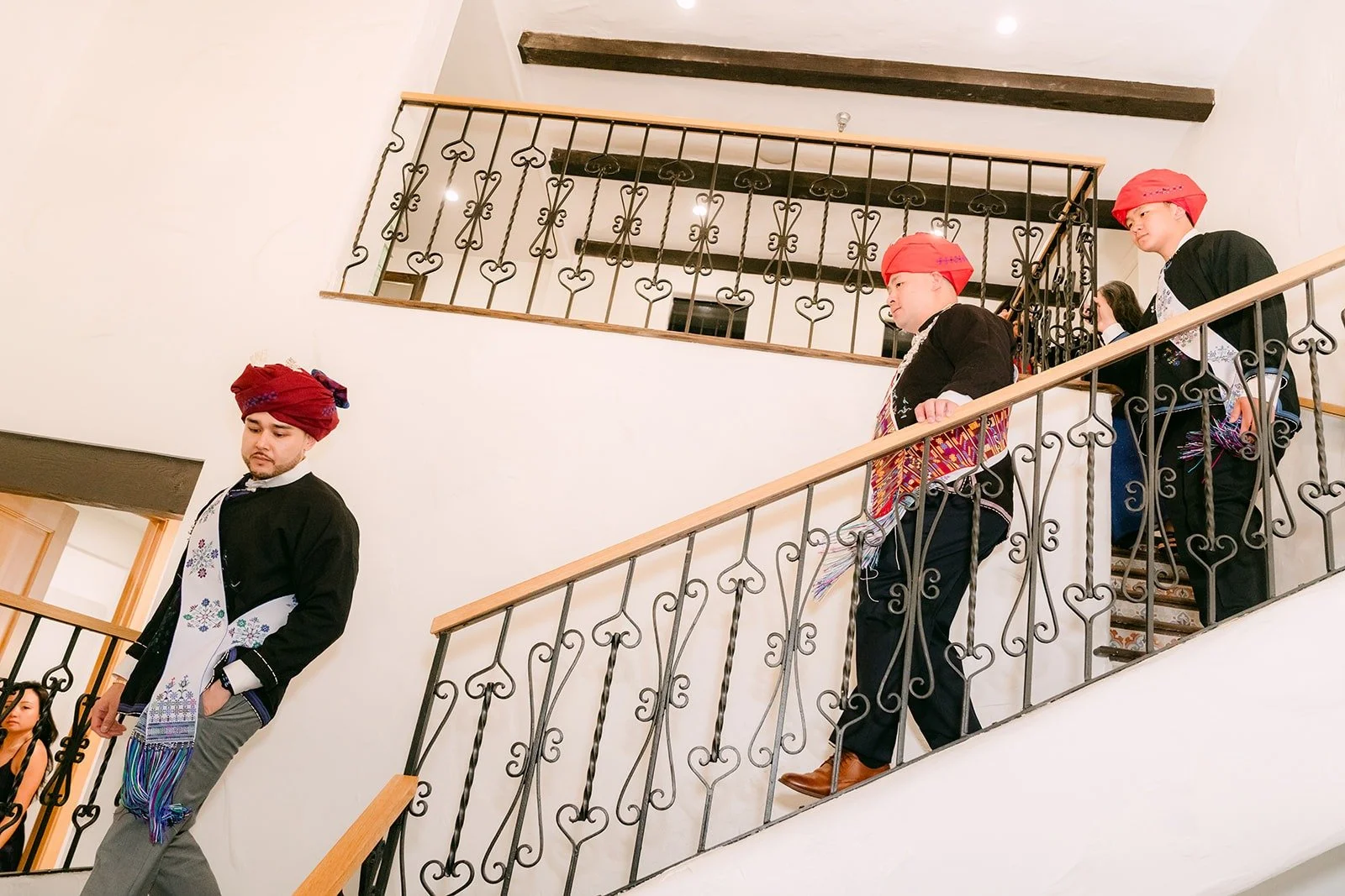 Family in traditional Mien dress waiting on the staircase