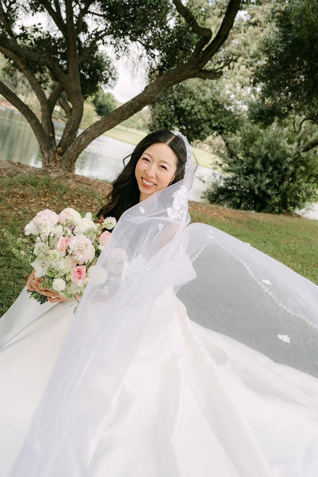Kristine's gown and veil fanned out on the lawn, photographed by One and Only Production