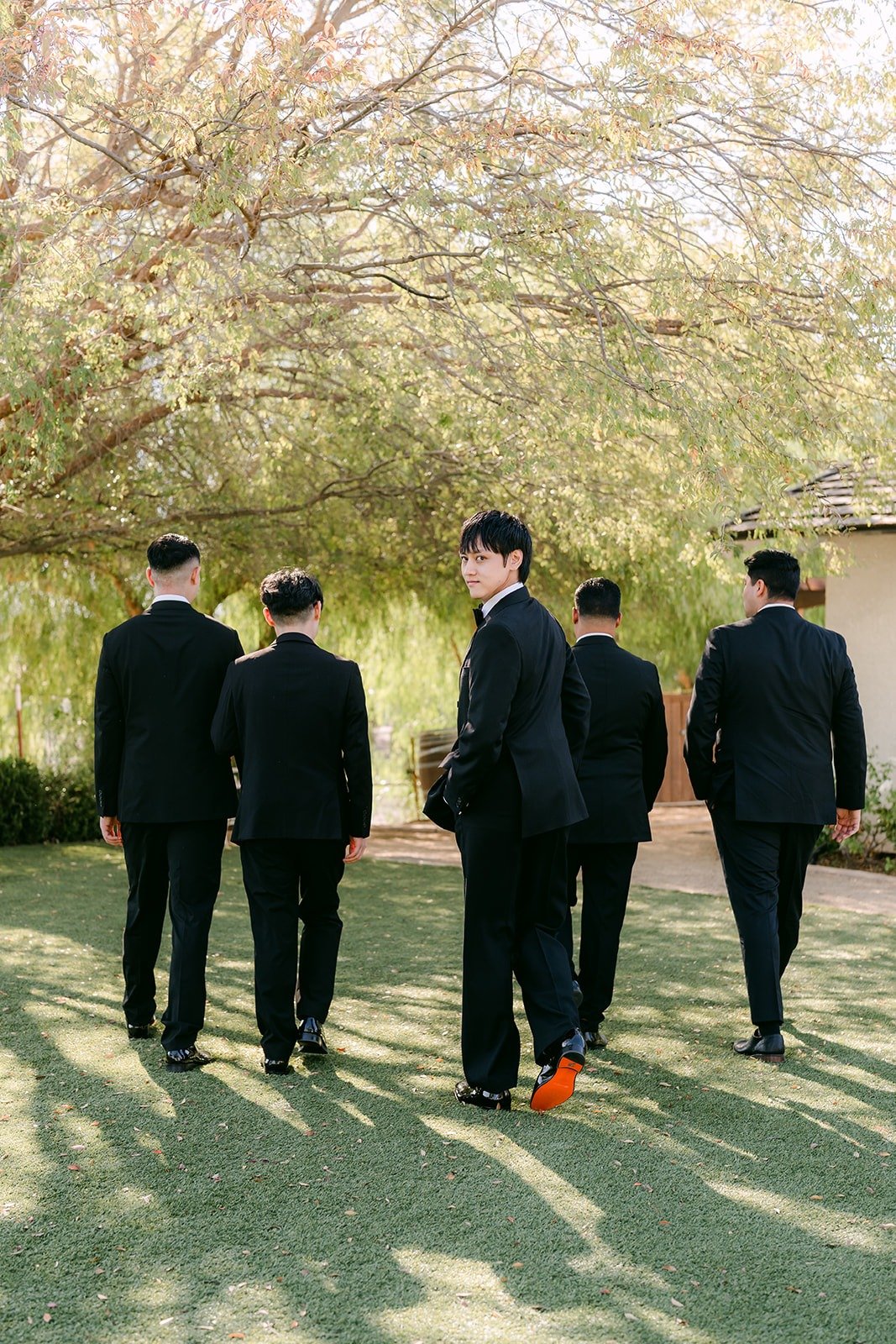 Groomsmen walking across the lawn together