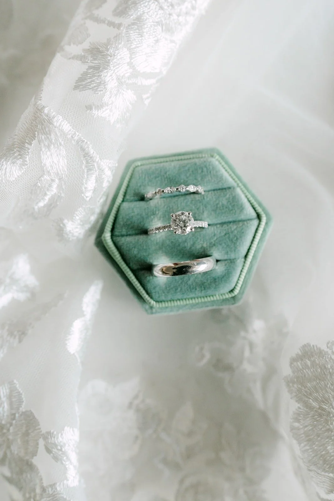 Wedding bands in a sage green velvet hexagon ring box