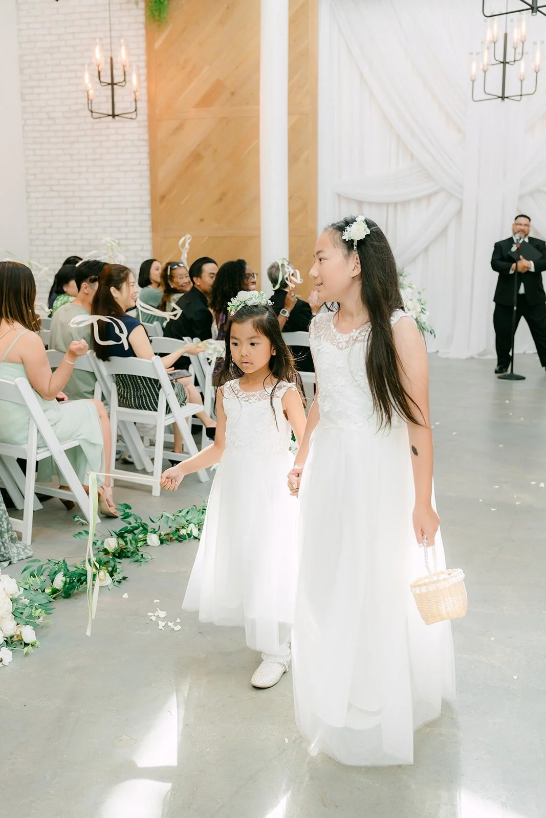 The flower girls walking down the aisle, photographed by One and Only Production