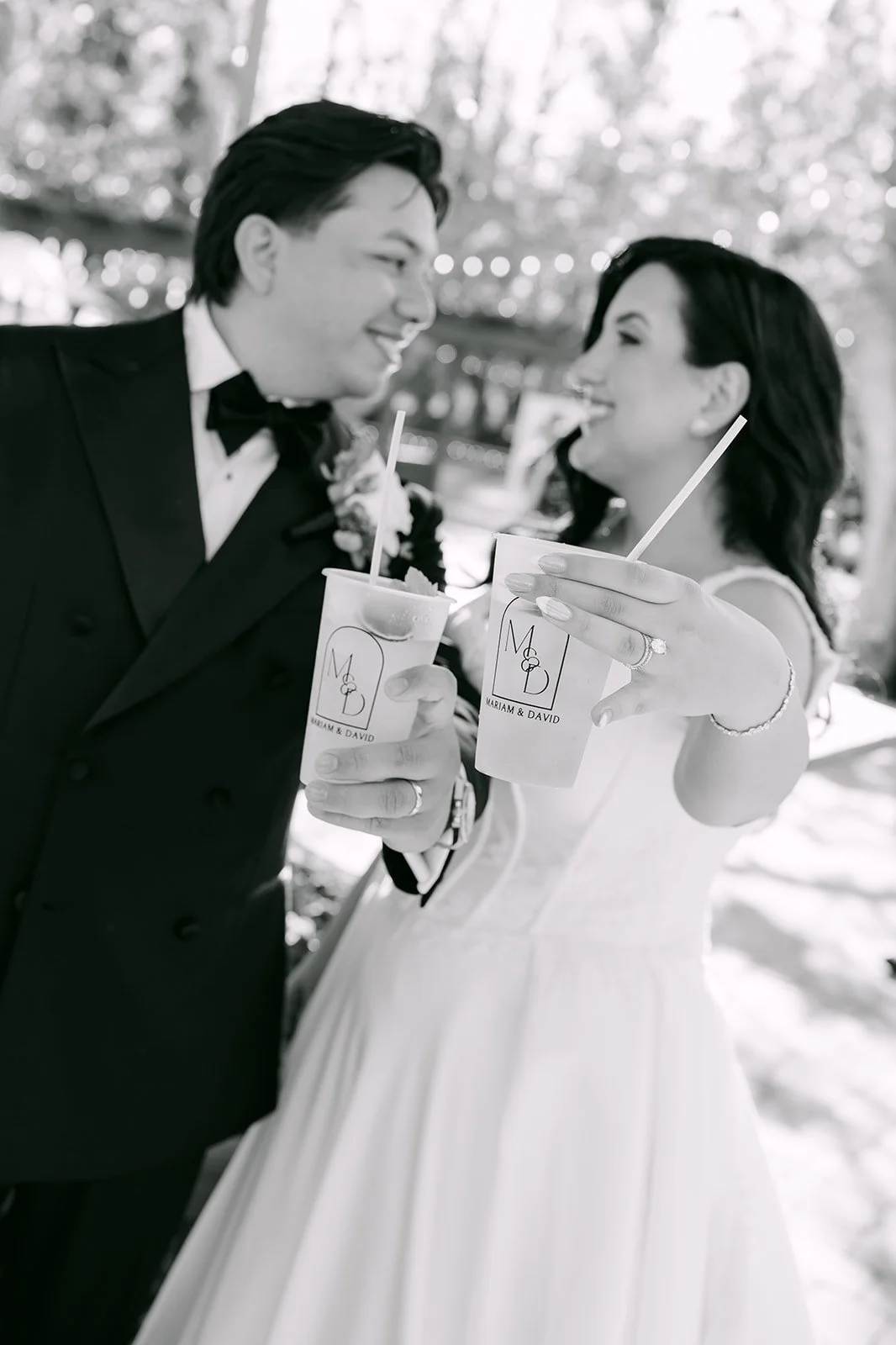 Black and white photo of the couple toasting with drinks