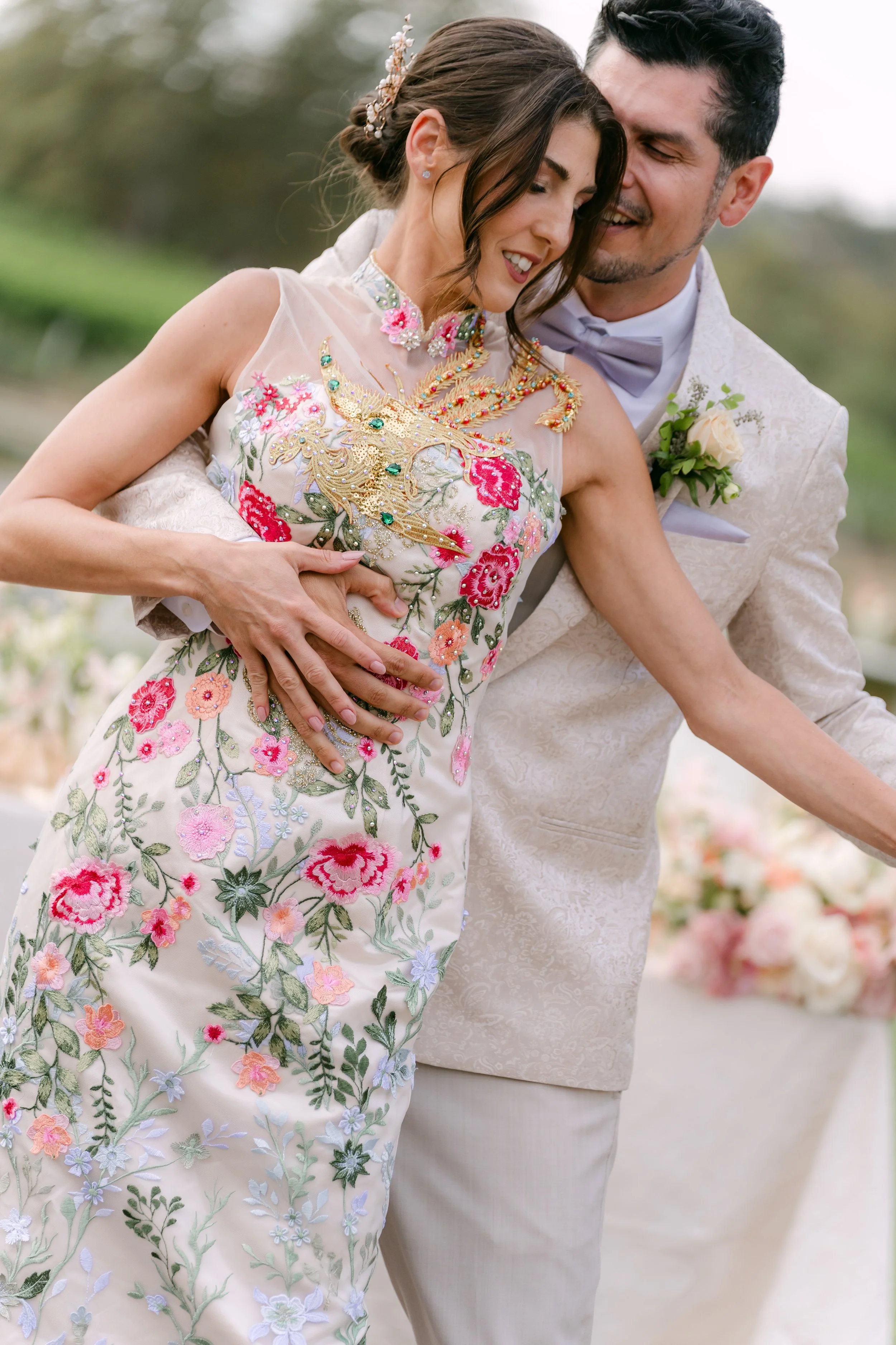 Couple embracing, the bride in a floral embroidered gown, at Monserate Winery