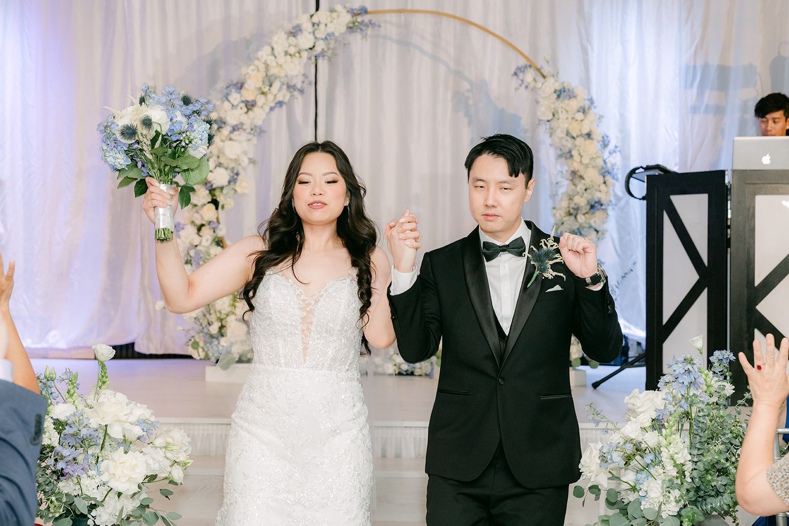 Emily and James walking back down the aisle past the floral arch