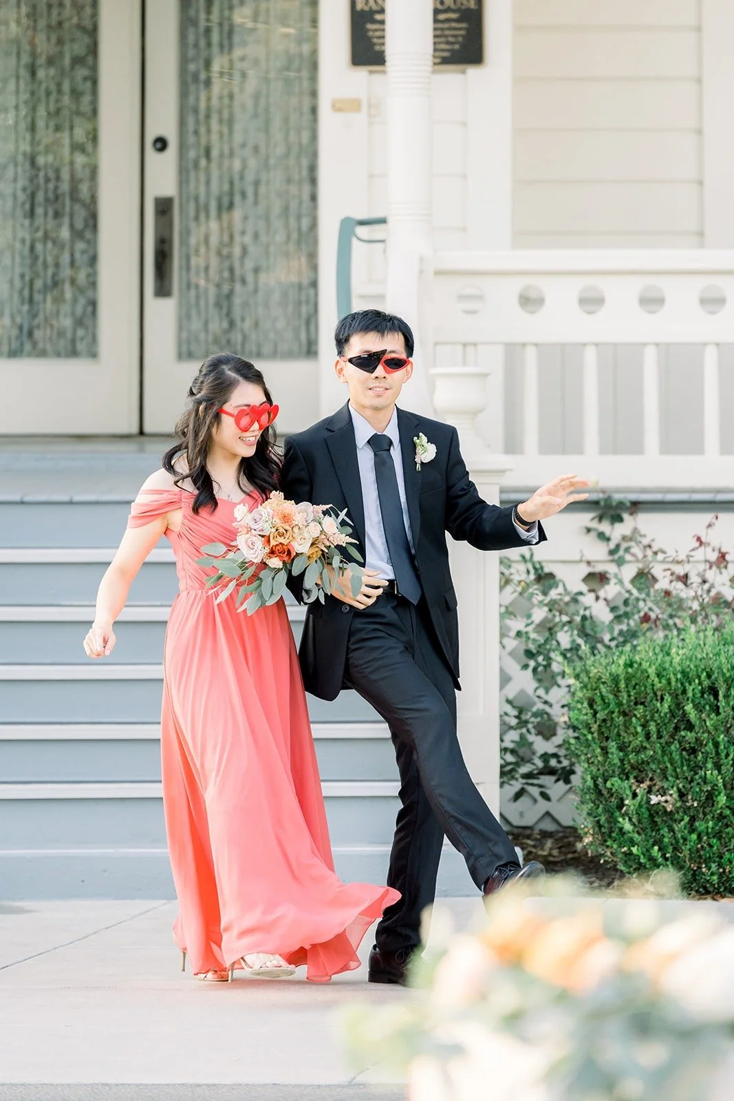 A bridesmaid and groomsman in sunglasses making their grand entrance