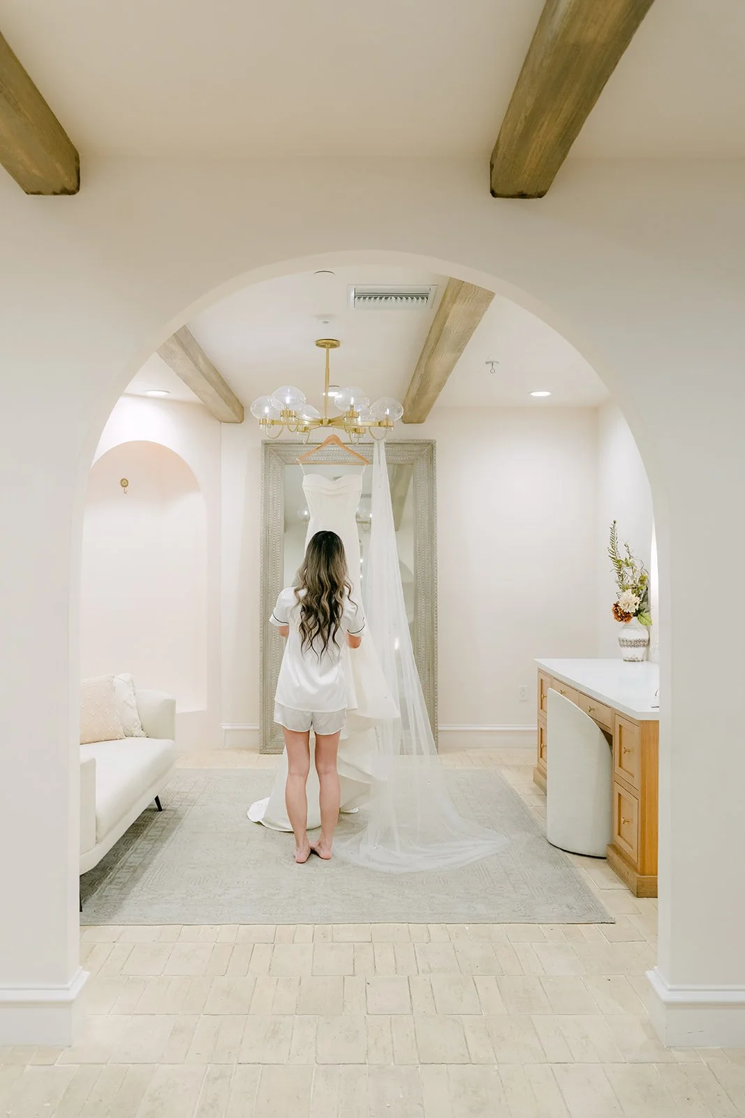 Kieu standing in the arched doorway of the bridal suite looking at her gown