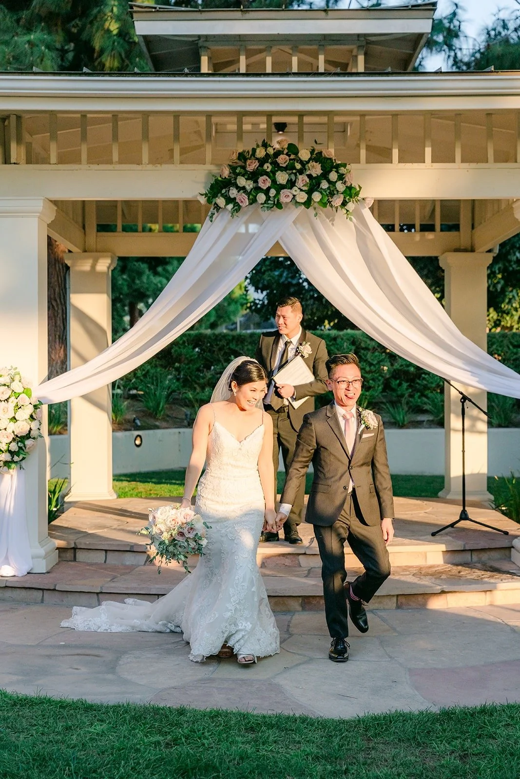 Xuemin and Alex walking down the gazebo steps as newlyweds