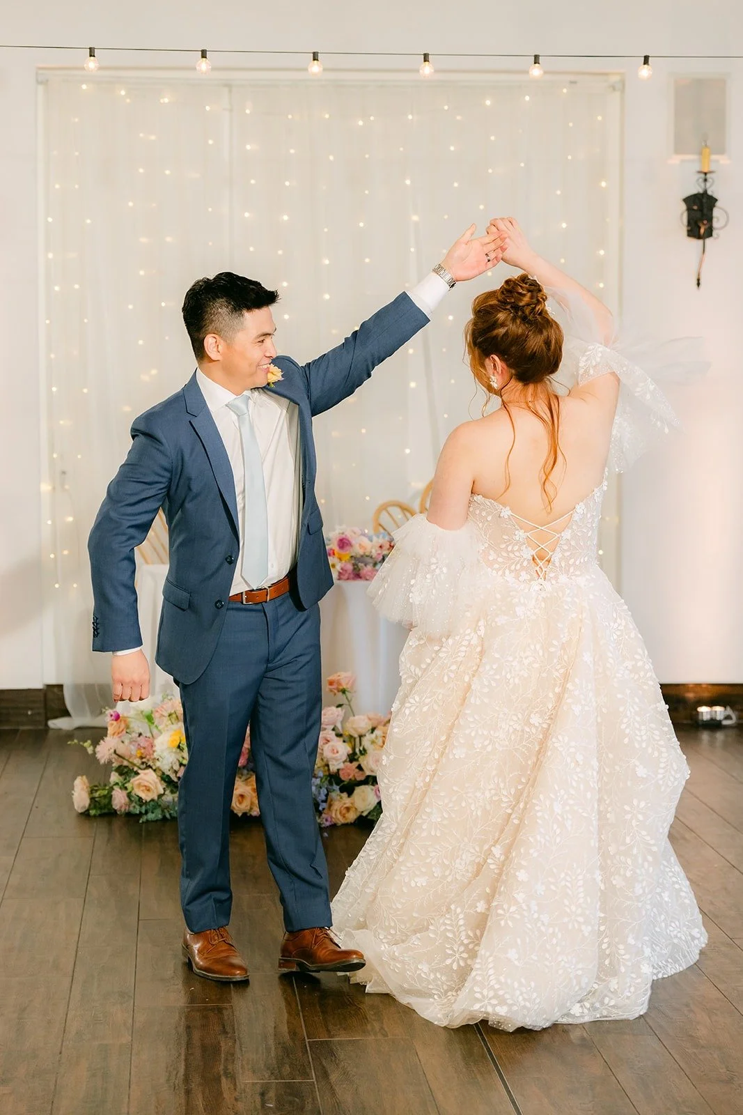 Joanna and Jerrick throwing their arms up as they start their first dance