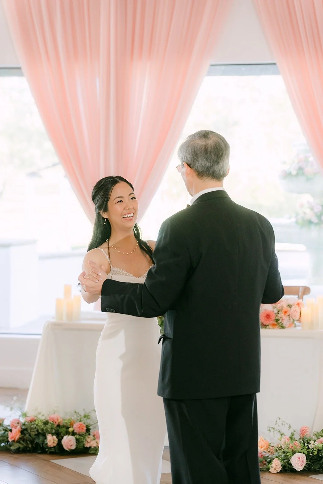 Stephanie smiling over her dance partner's shoulder during the parent dances