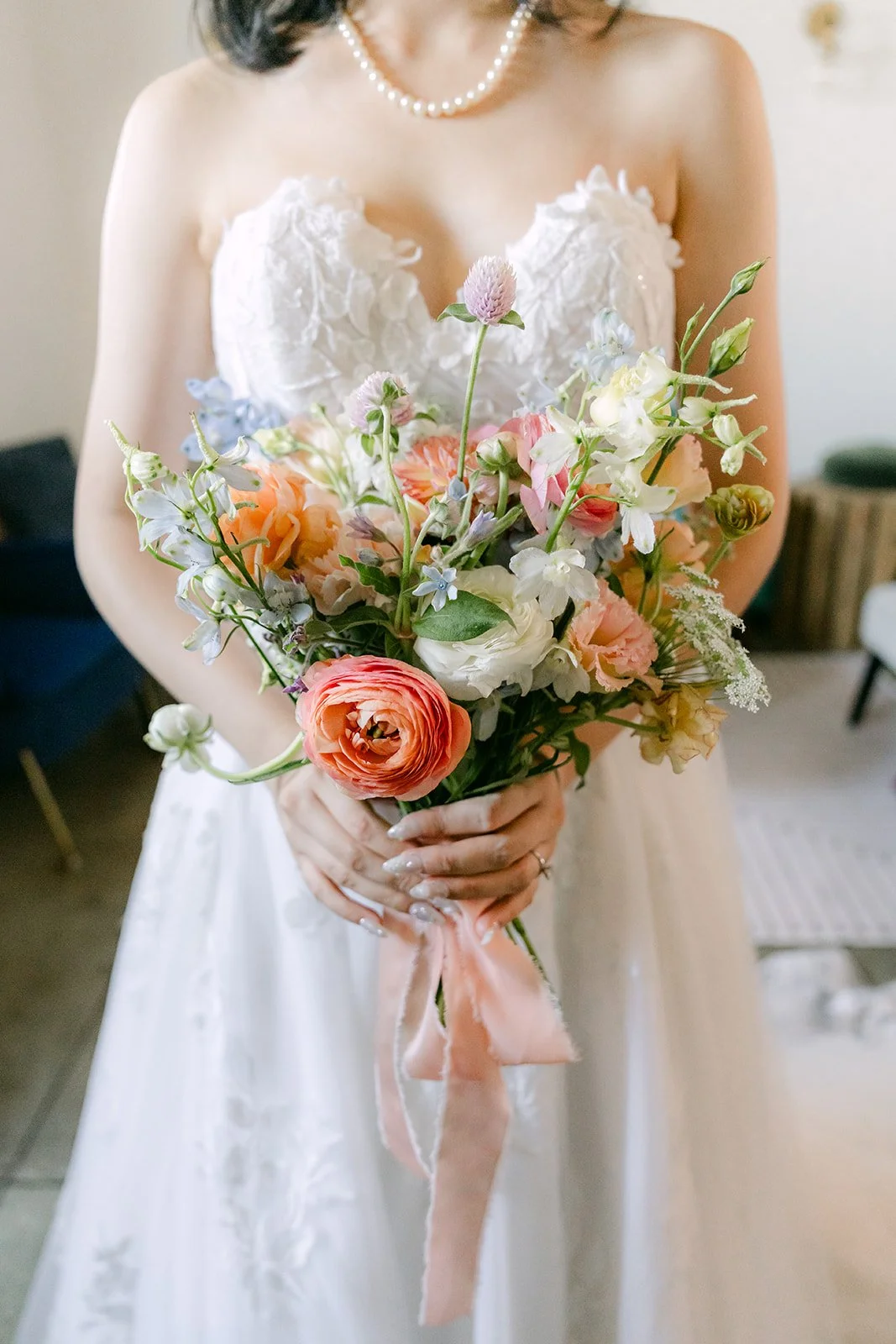 Close up of Vivian's bouquet of peach roses and white blooms