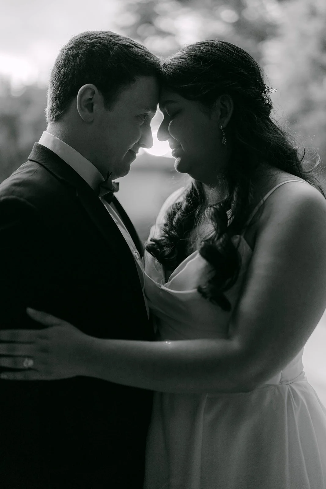 A black and white portrait of Saira and Matthew forehead to forehead