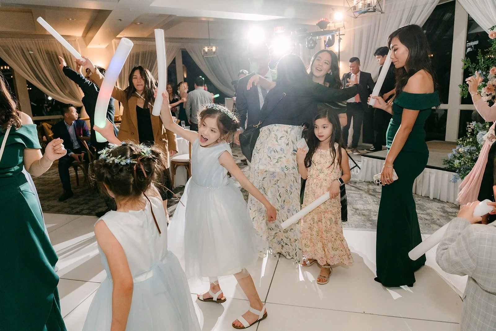 Guests waving light up foam sticks on the dance floor
