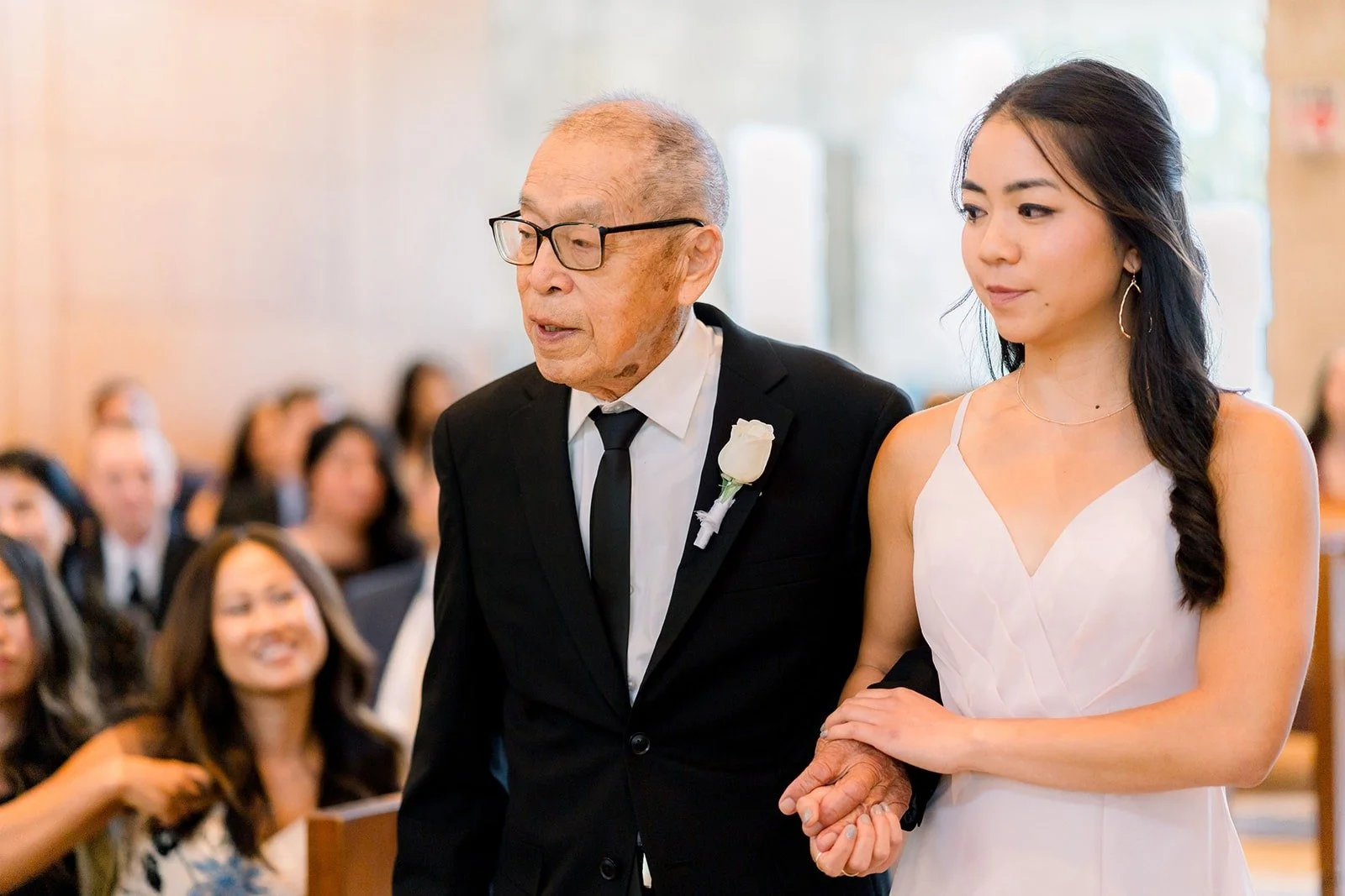 Jacinda walks down the aisle on the arm of a family member