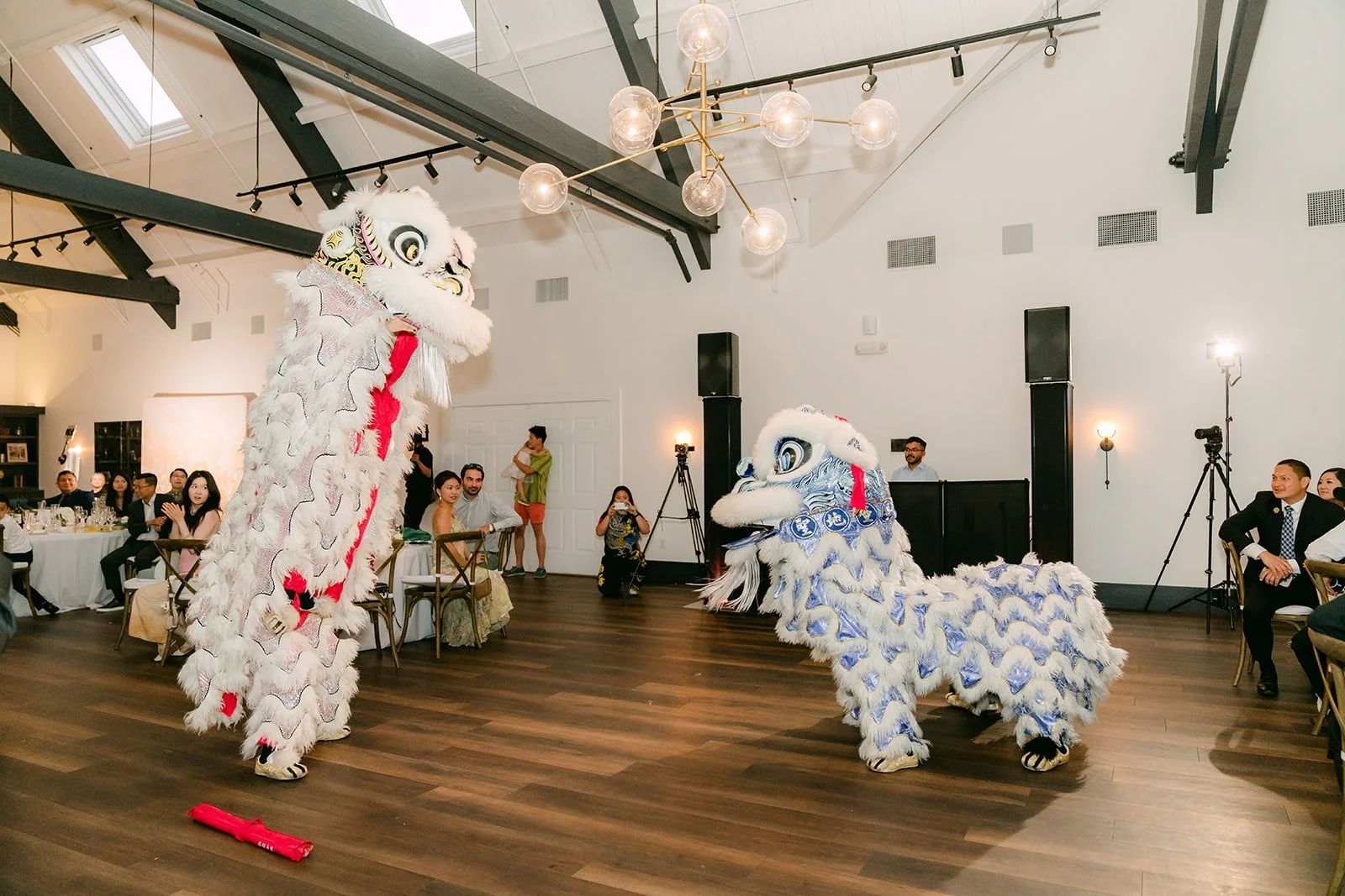 Two lion dancers moving across the dance floor