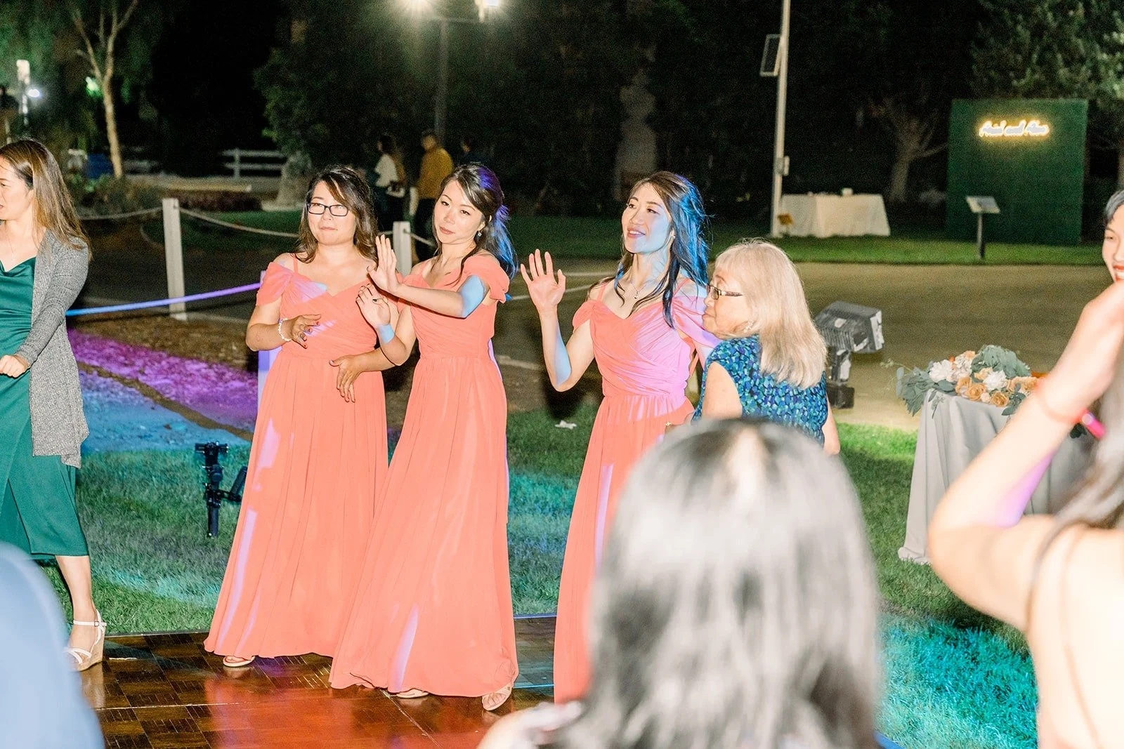 Bridesmaids dancing on the colorful dance floor