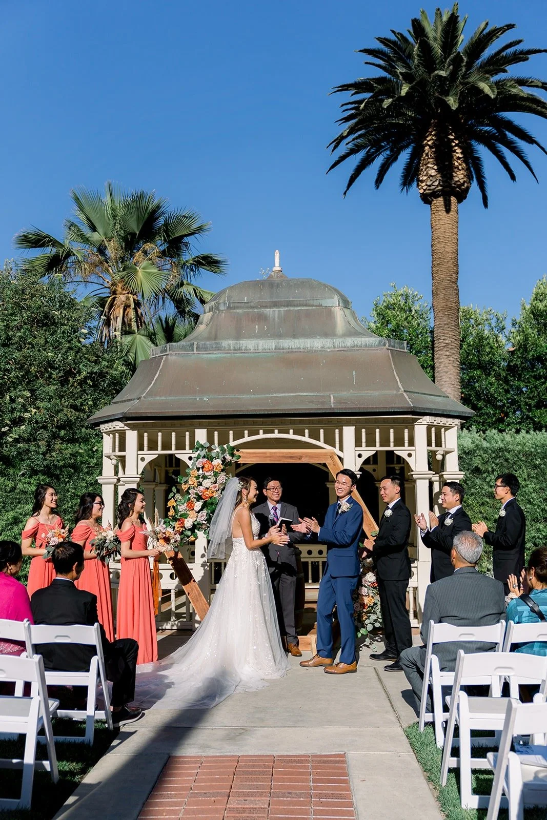 Ariel and Alex under the gazebo framed by palm trees