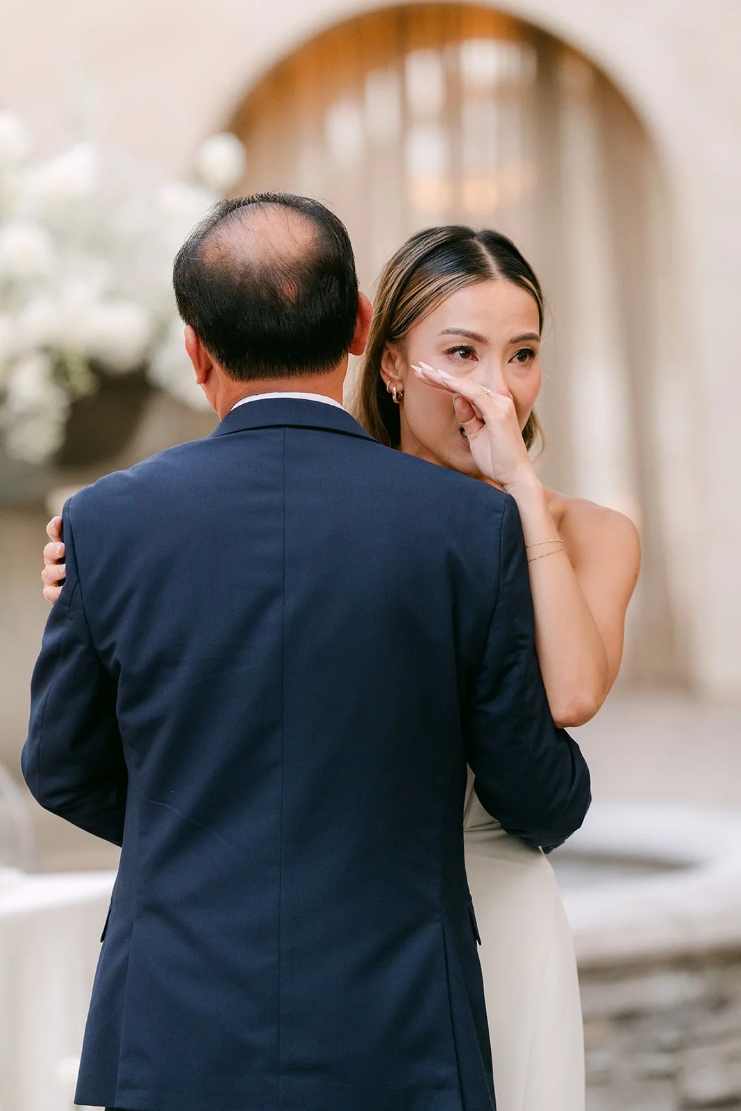 Kieu dancing with her father as she wipes away a tear