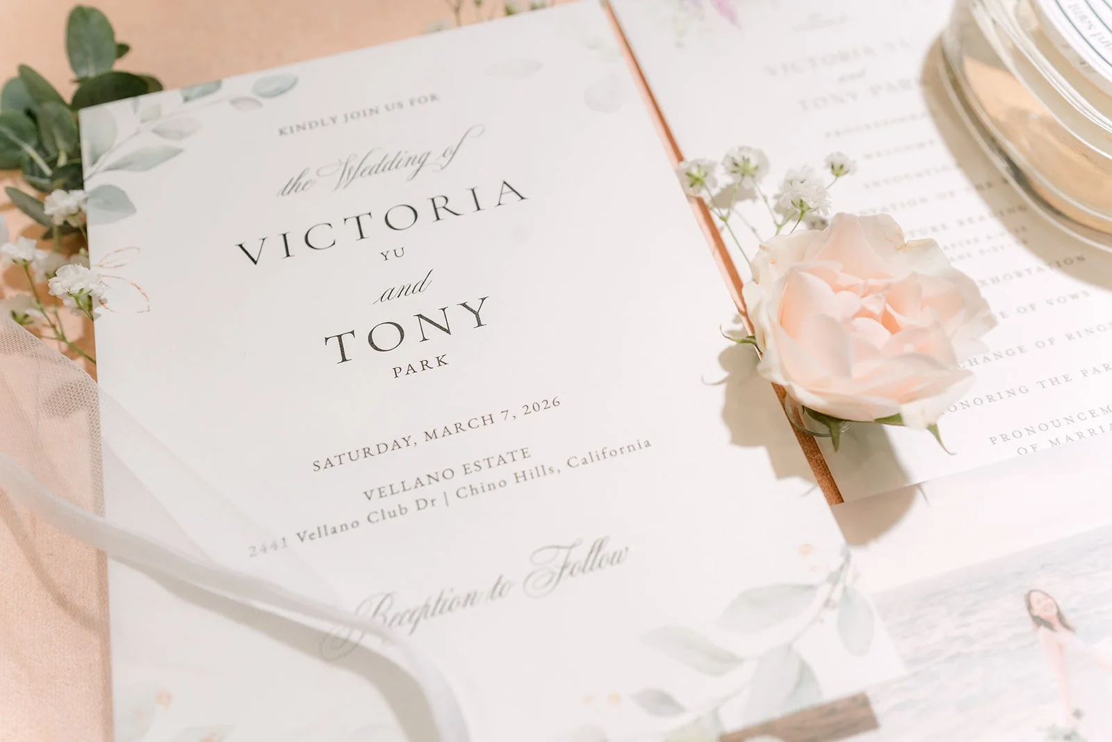 Victoria and Tony's wedding invitation styled with blush garden roses