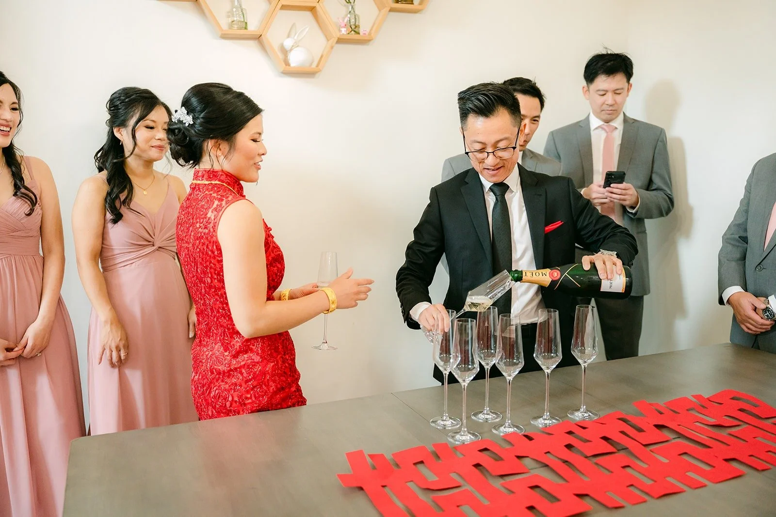 Alex and the groomsmen at a table during the door games, with the bridesmaids looking on