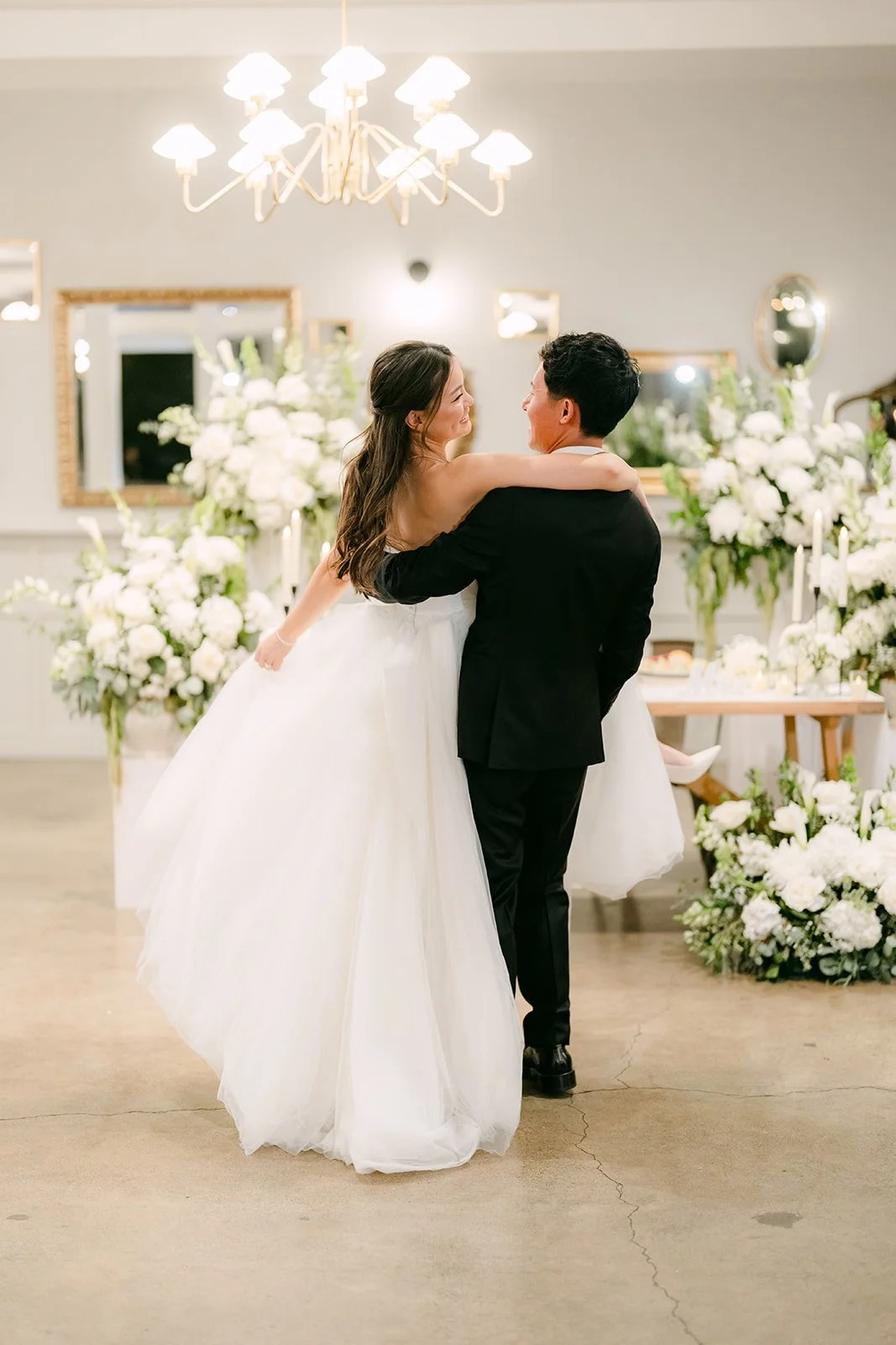 Private dance among the tables under the chandeliers