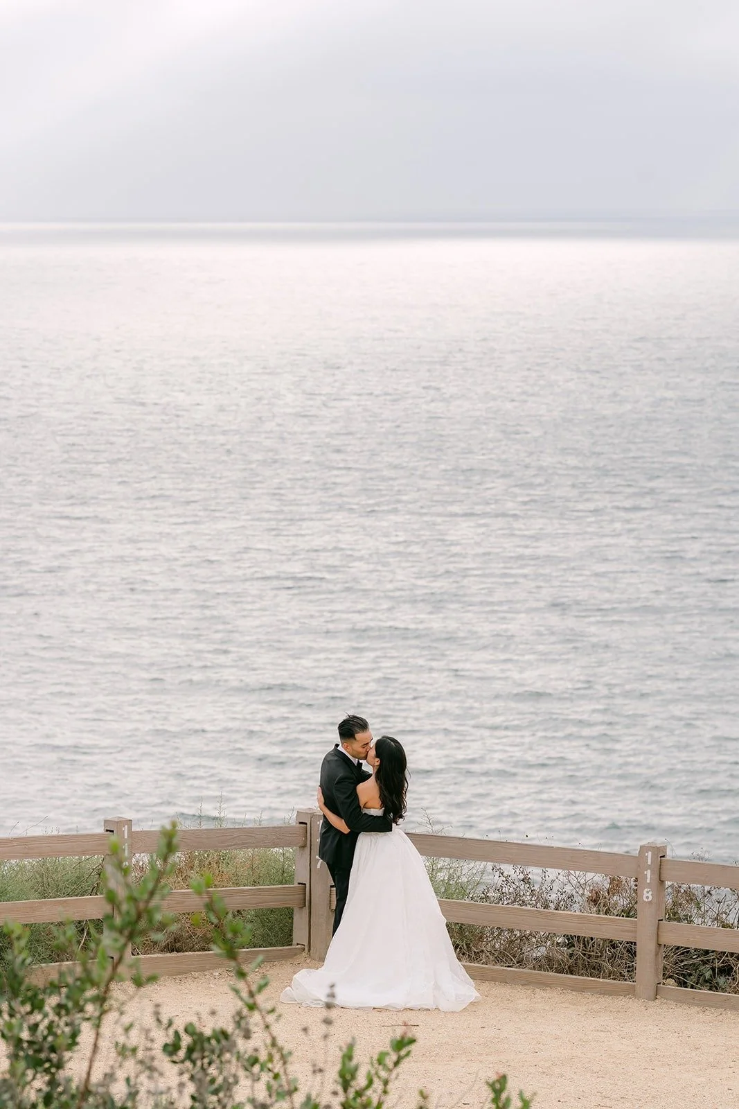 Kim and Vincent on the bluff with the ocean behind them