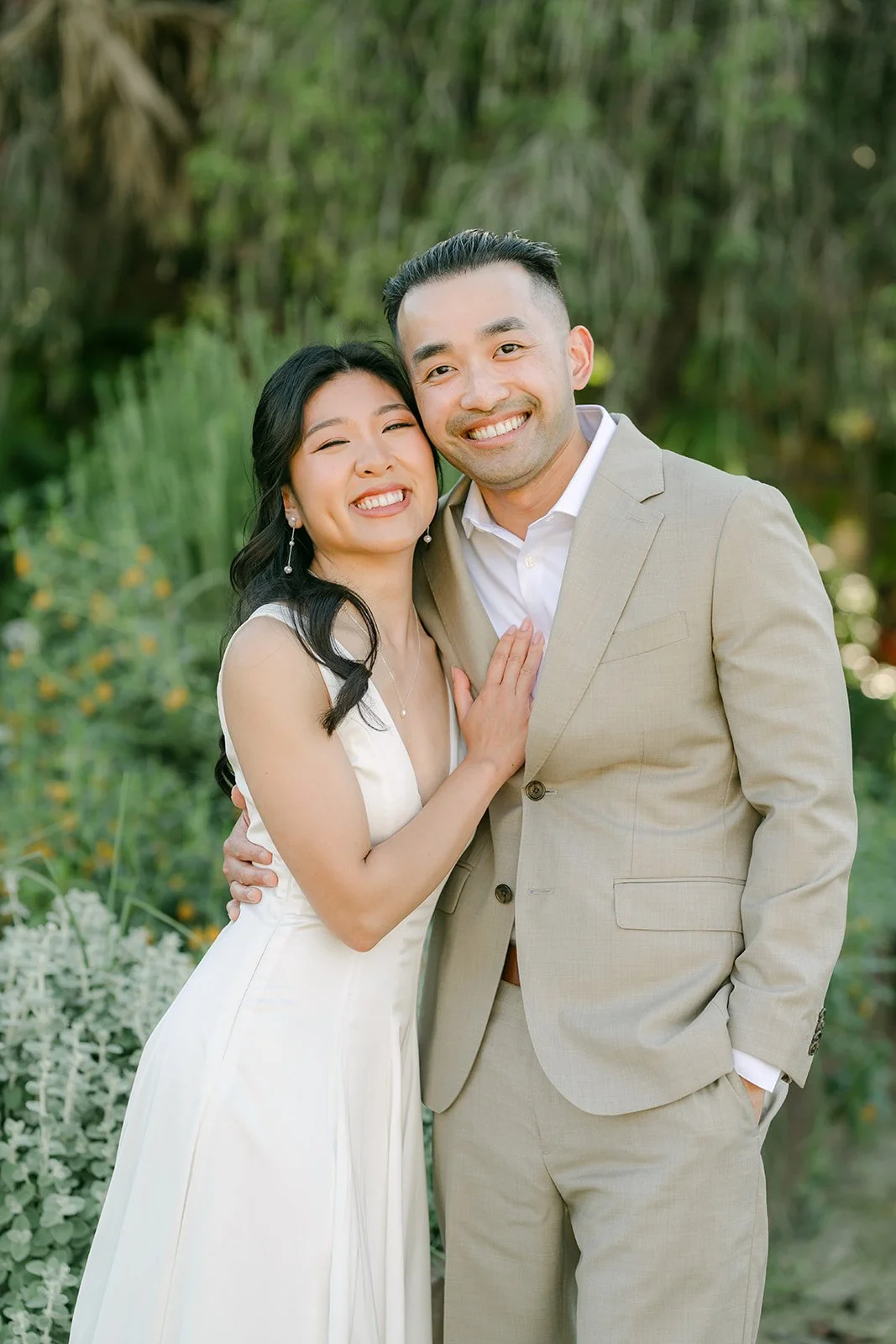 Kim and Vincent smiling together among the greenery.