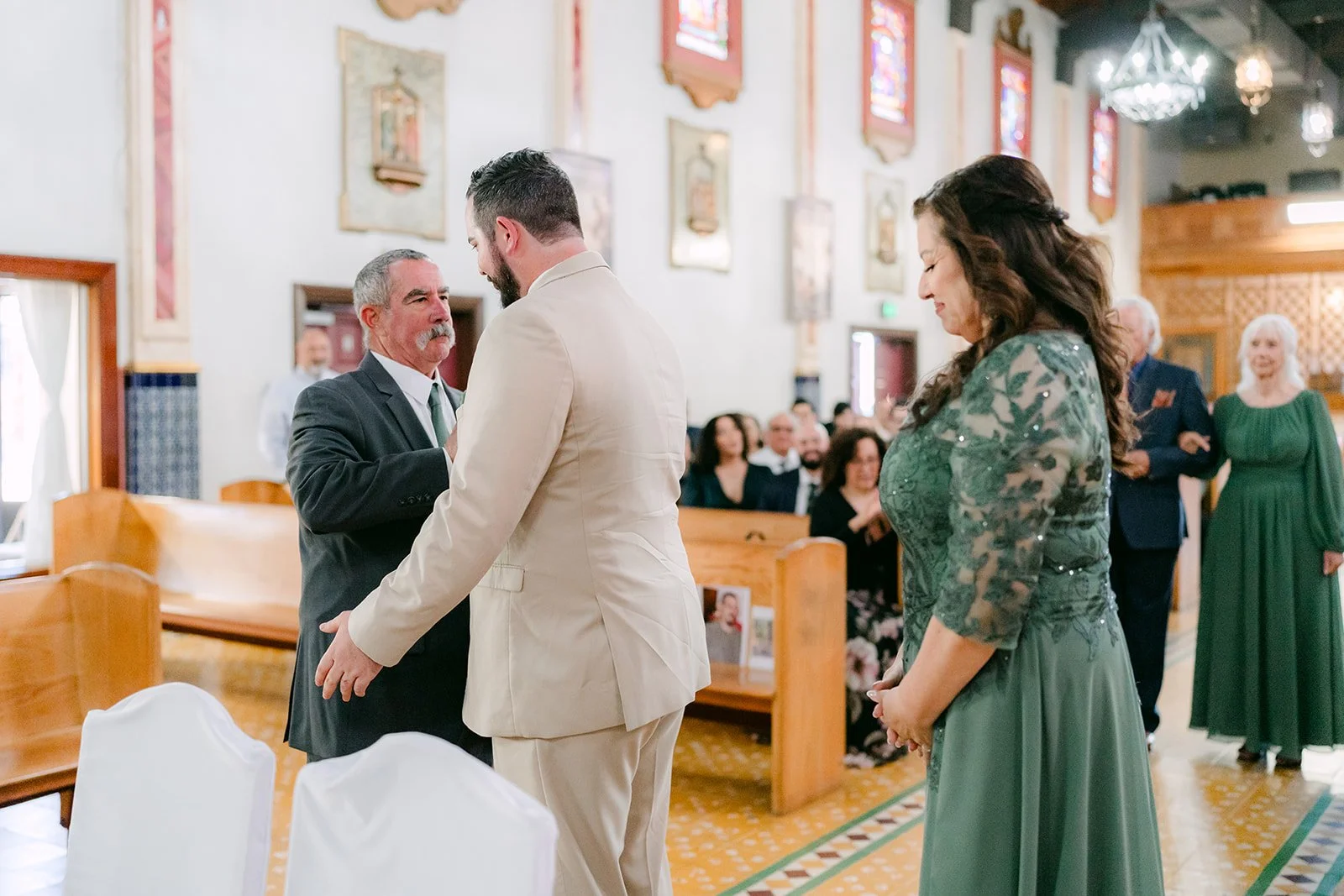 A bridesmaid in sage walking down the aisle.