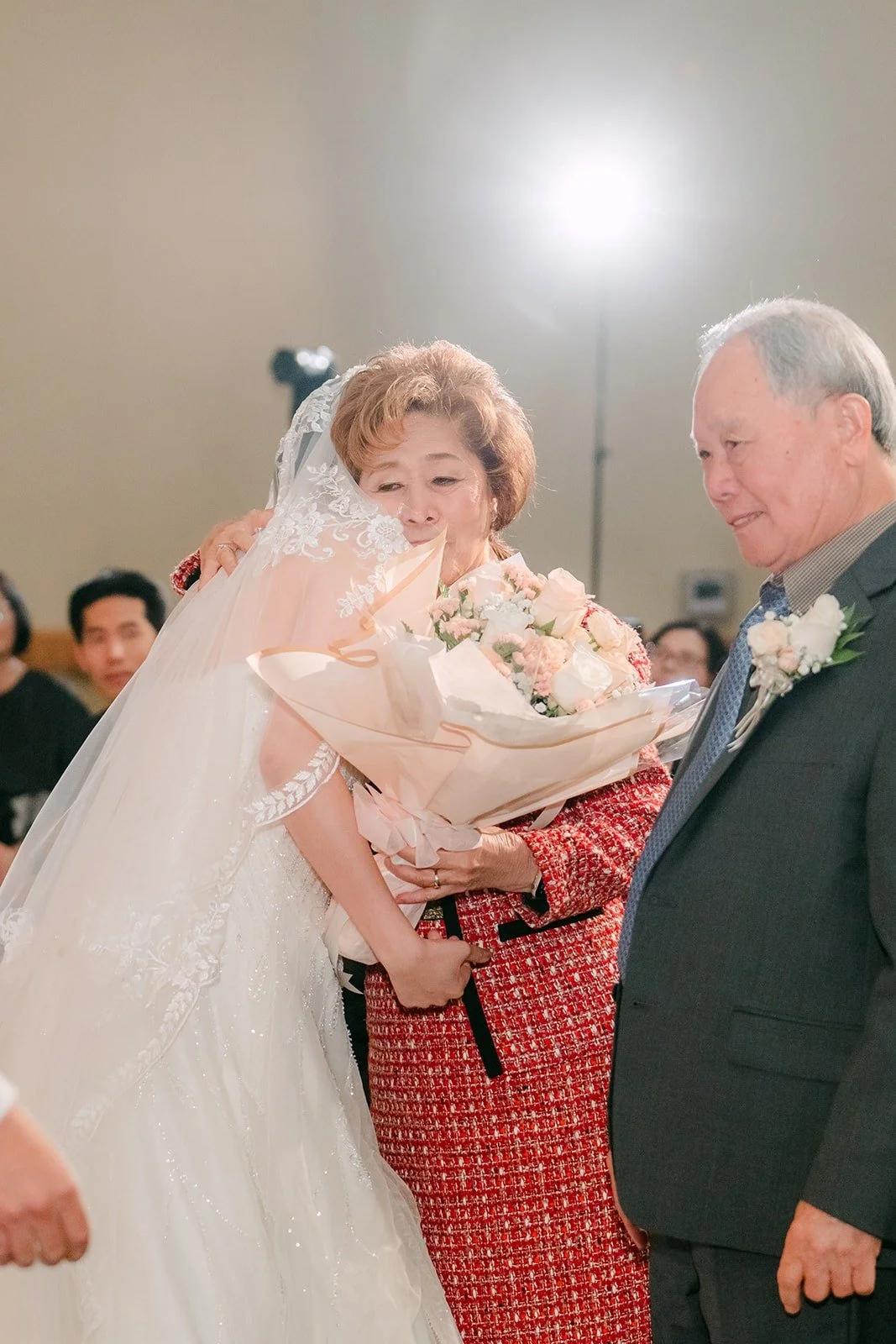 Eunice hugs a family member holding a bouquet of flowers
