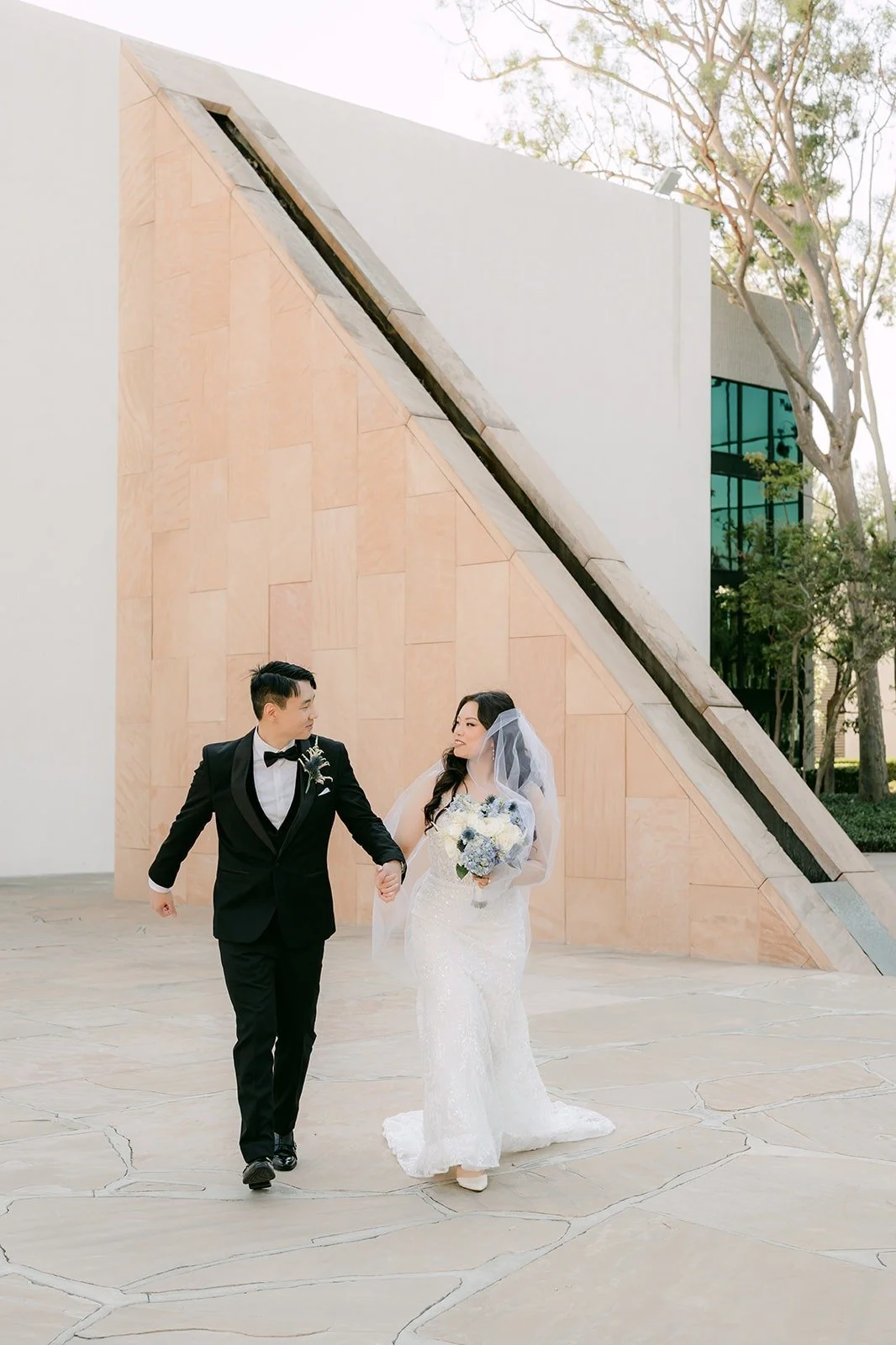 Emily and James laughing as they walk past the stone sculpture