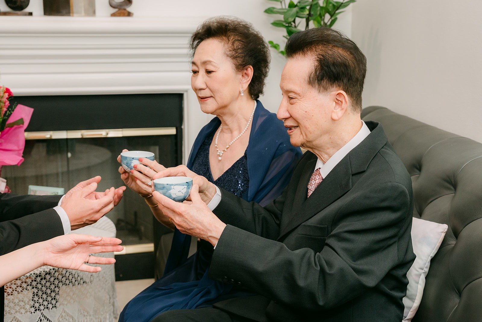 Eunice and Eric offer tea with both hands during the tea ceremony