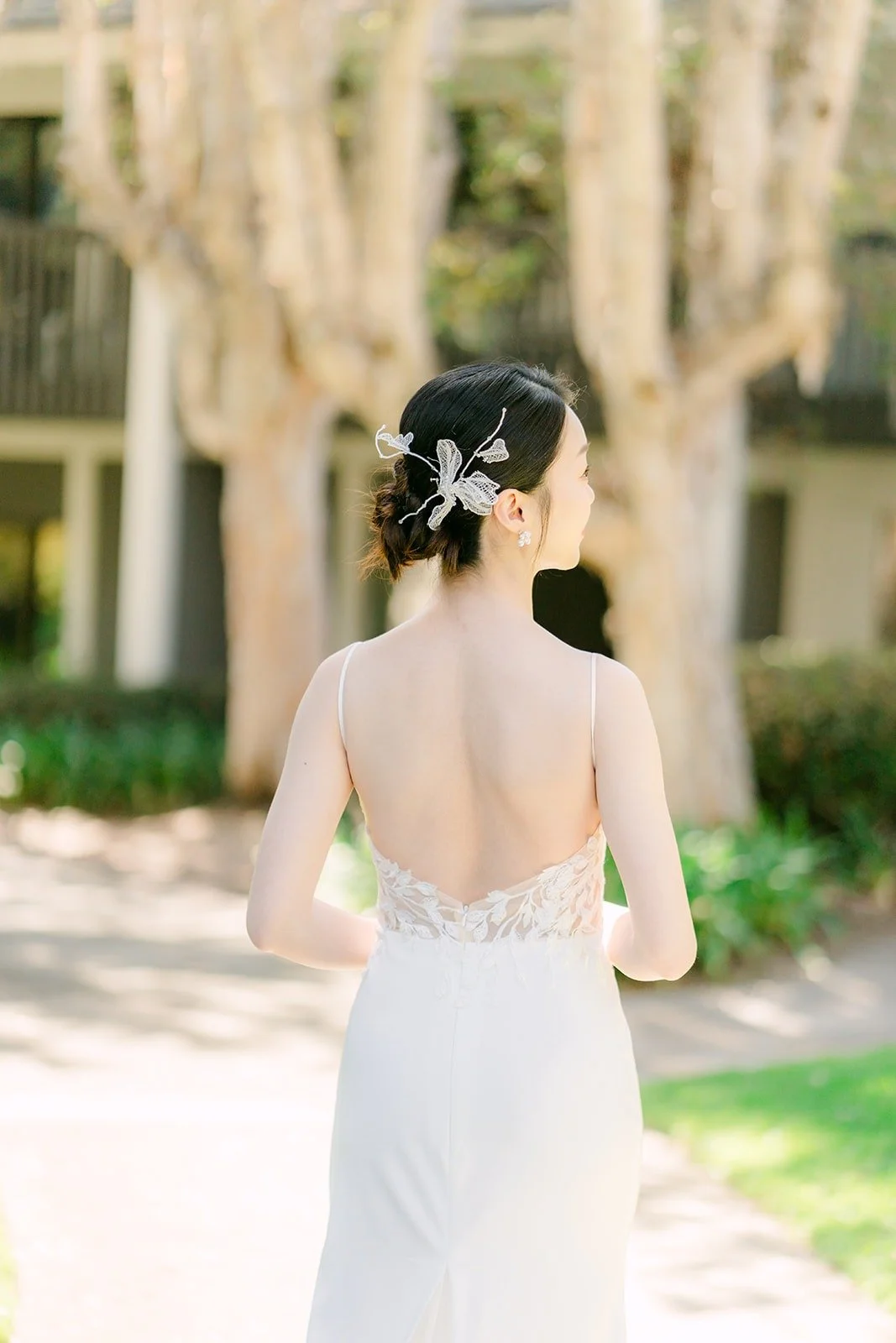 The open back of Tin's dress and her low bun