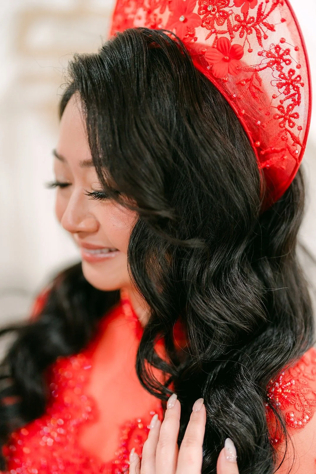 A close portrait of Jennifer's red lace headpiece and long dark curls