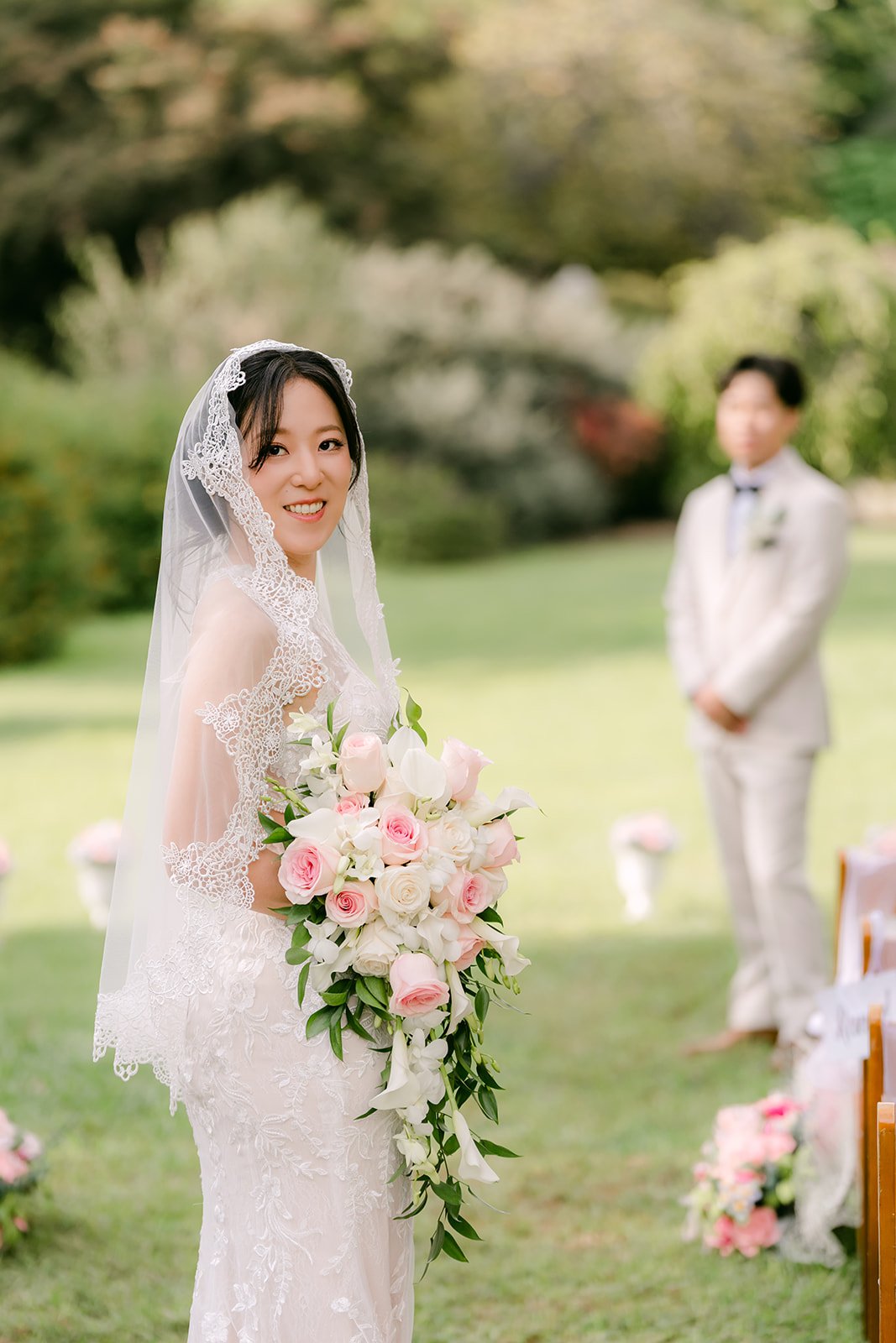 Elaine with her bouquet on the lawn as Wen looks on.