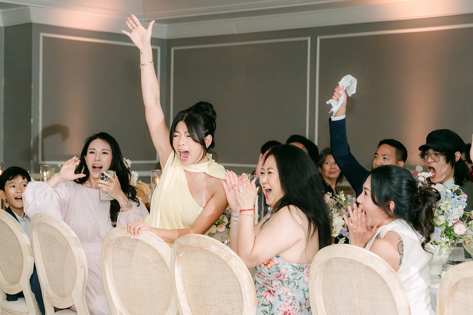 Guests cheering and waving napkins as the reception begins