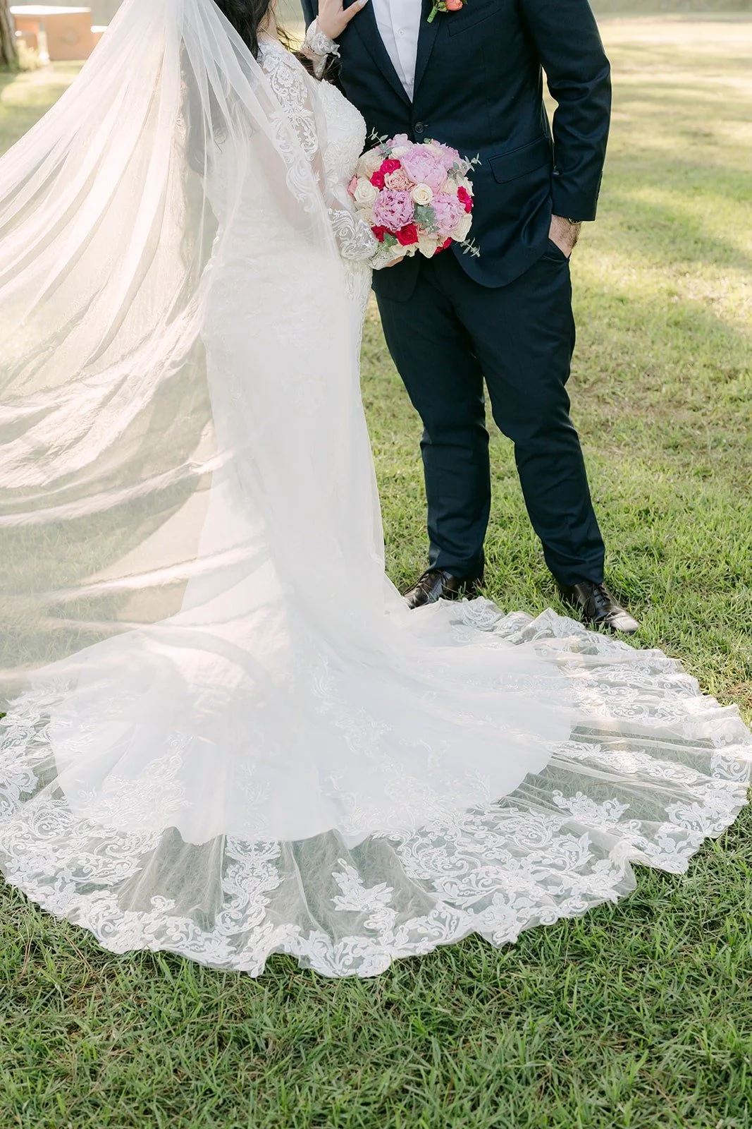 Amy's lace train fanned out on the grass beside James