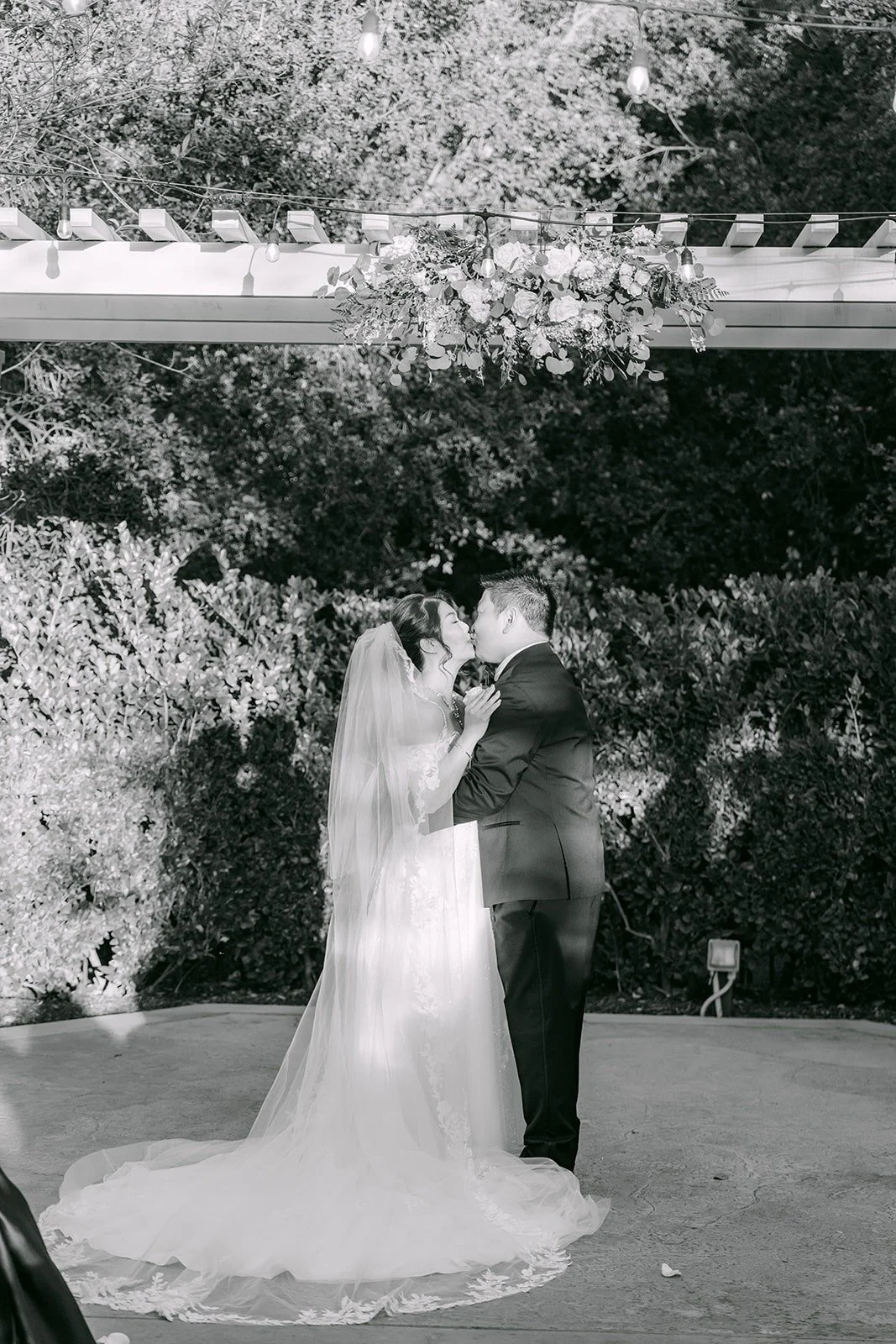 Sochi and Jay share their first kiss under the arbor, shown in black and white