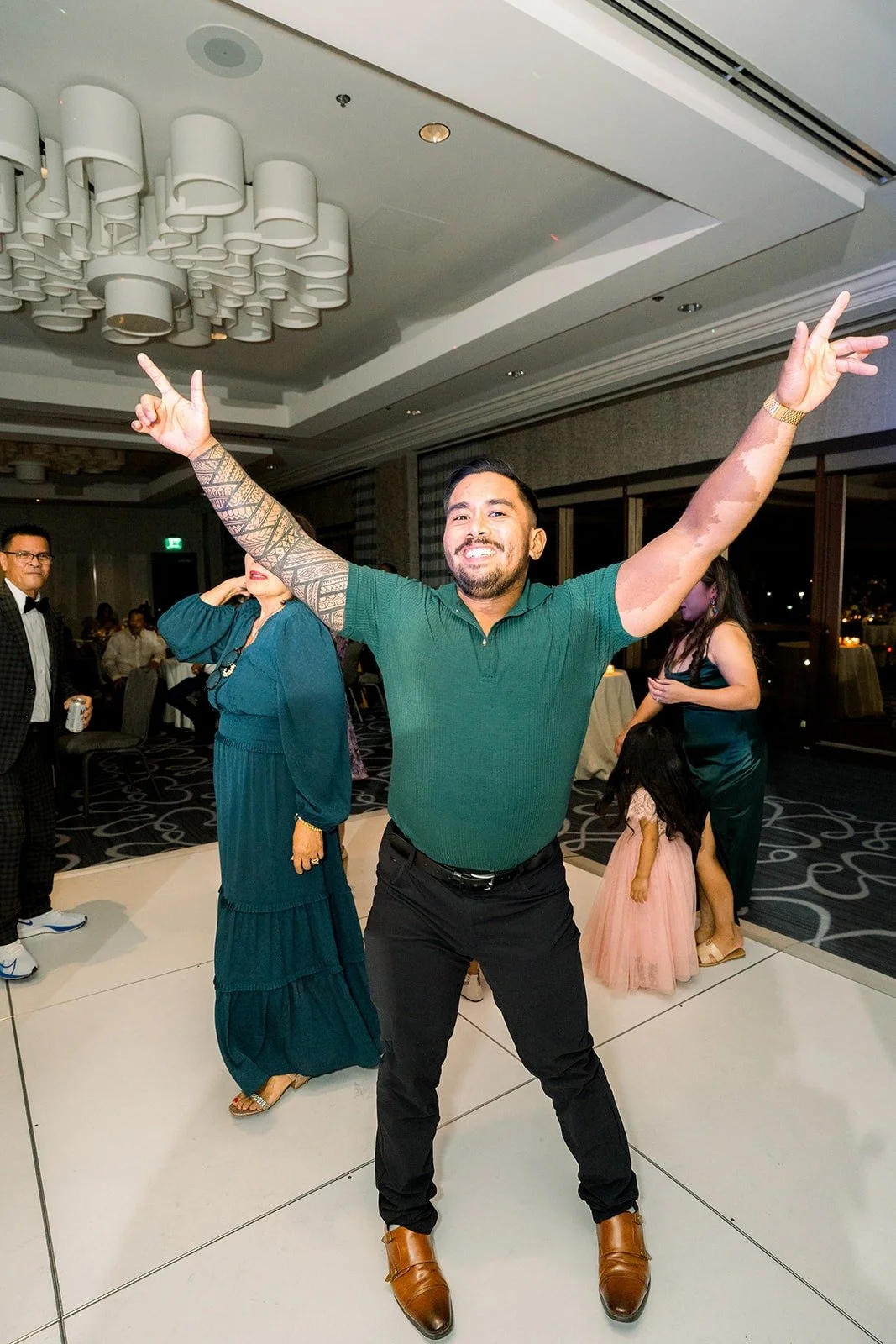 A guest throws both arms in the air on the dance floor