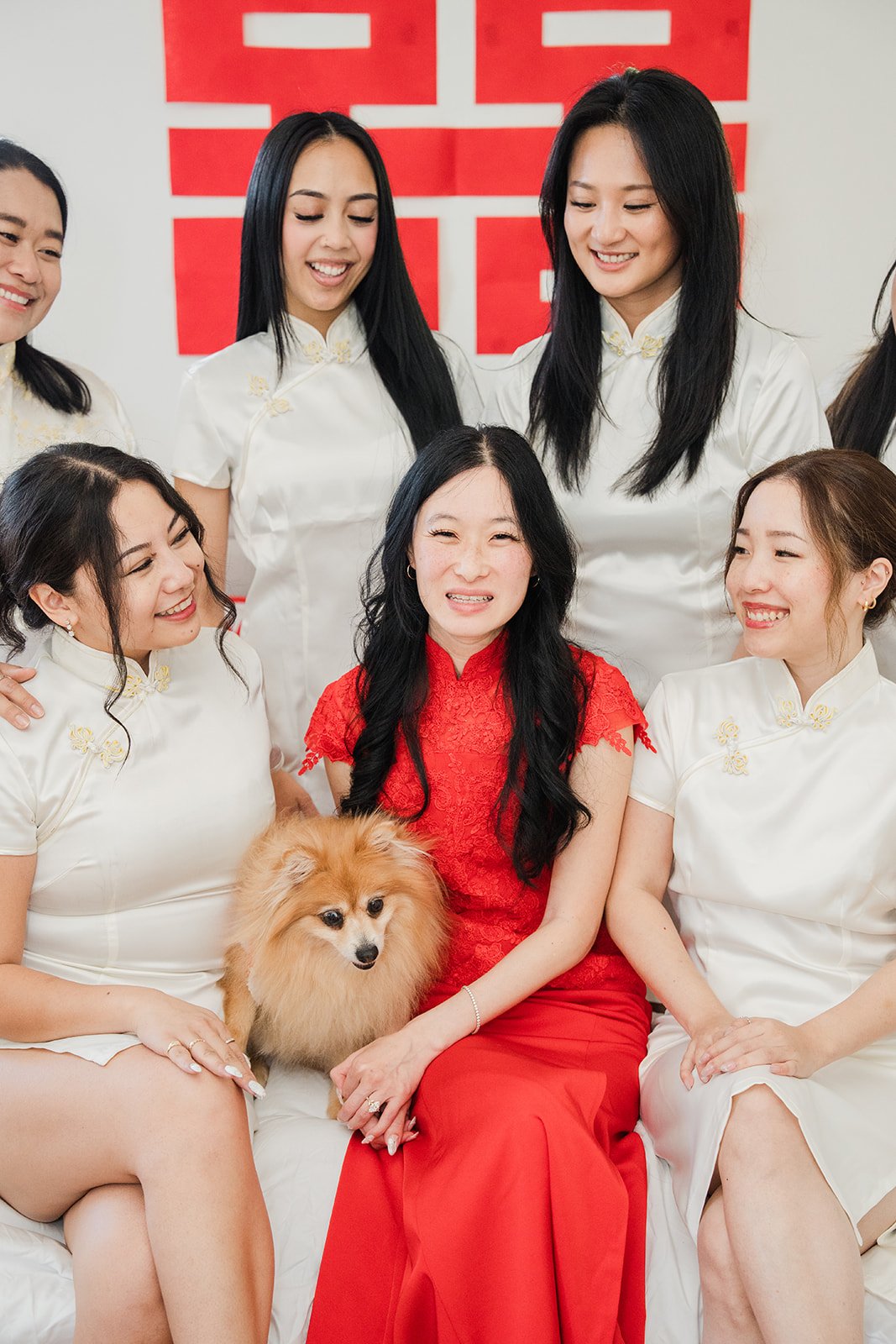 Valerie in a red qipao with her bridesmaids in white.