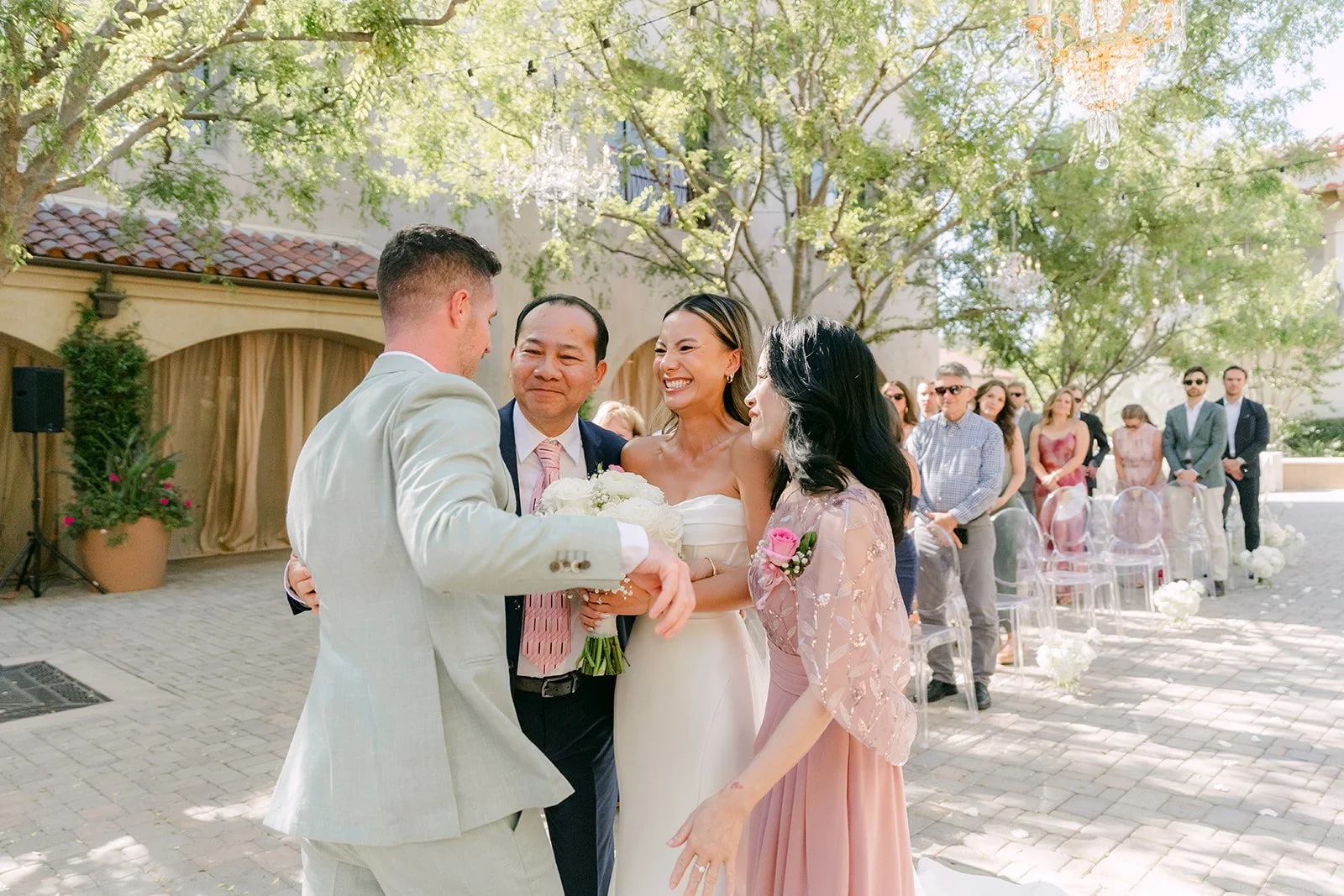 Bride's father hugging the groom at the end of the aisle
