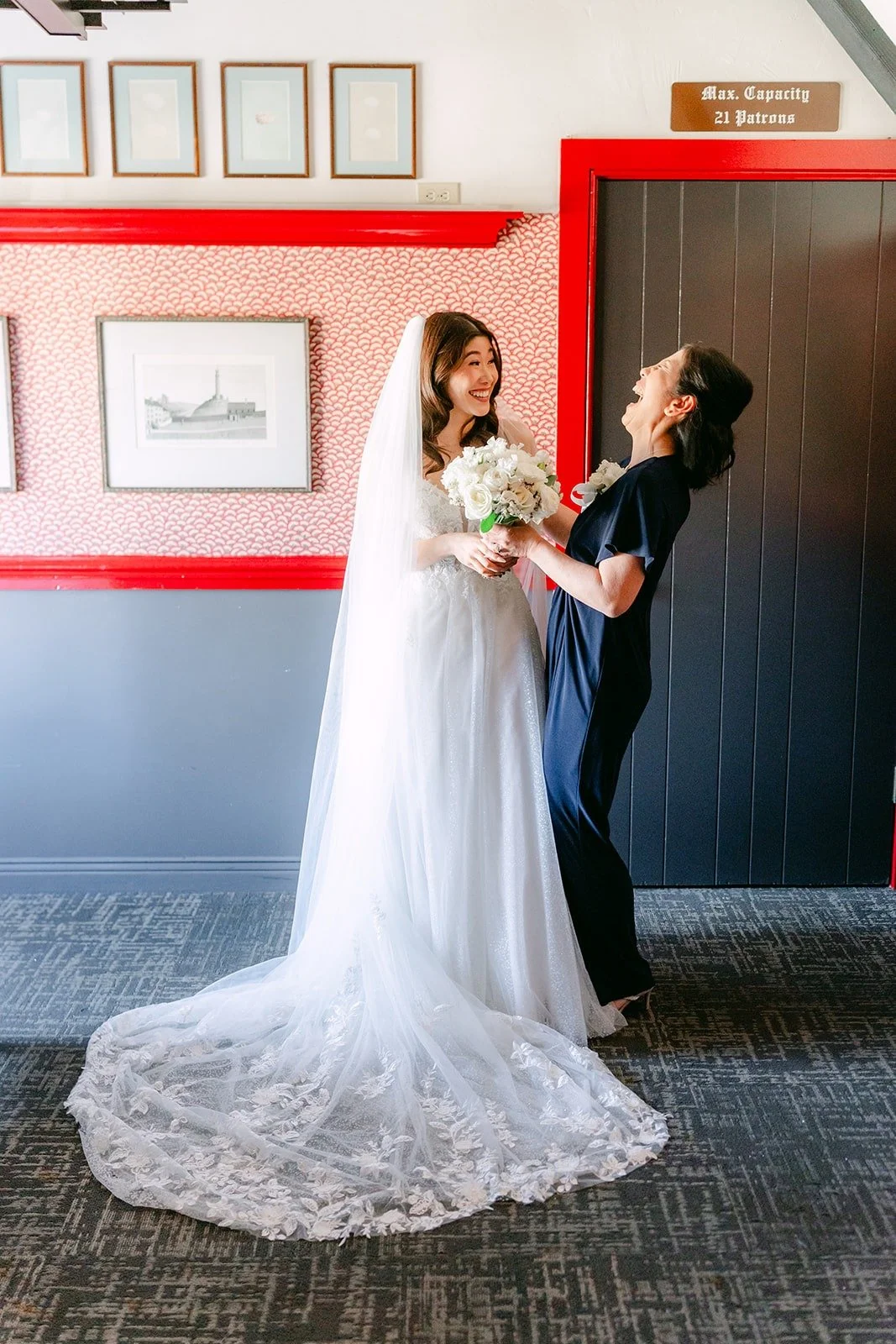A family member adjusting Valerie's veil and lace train